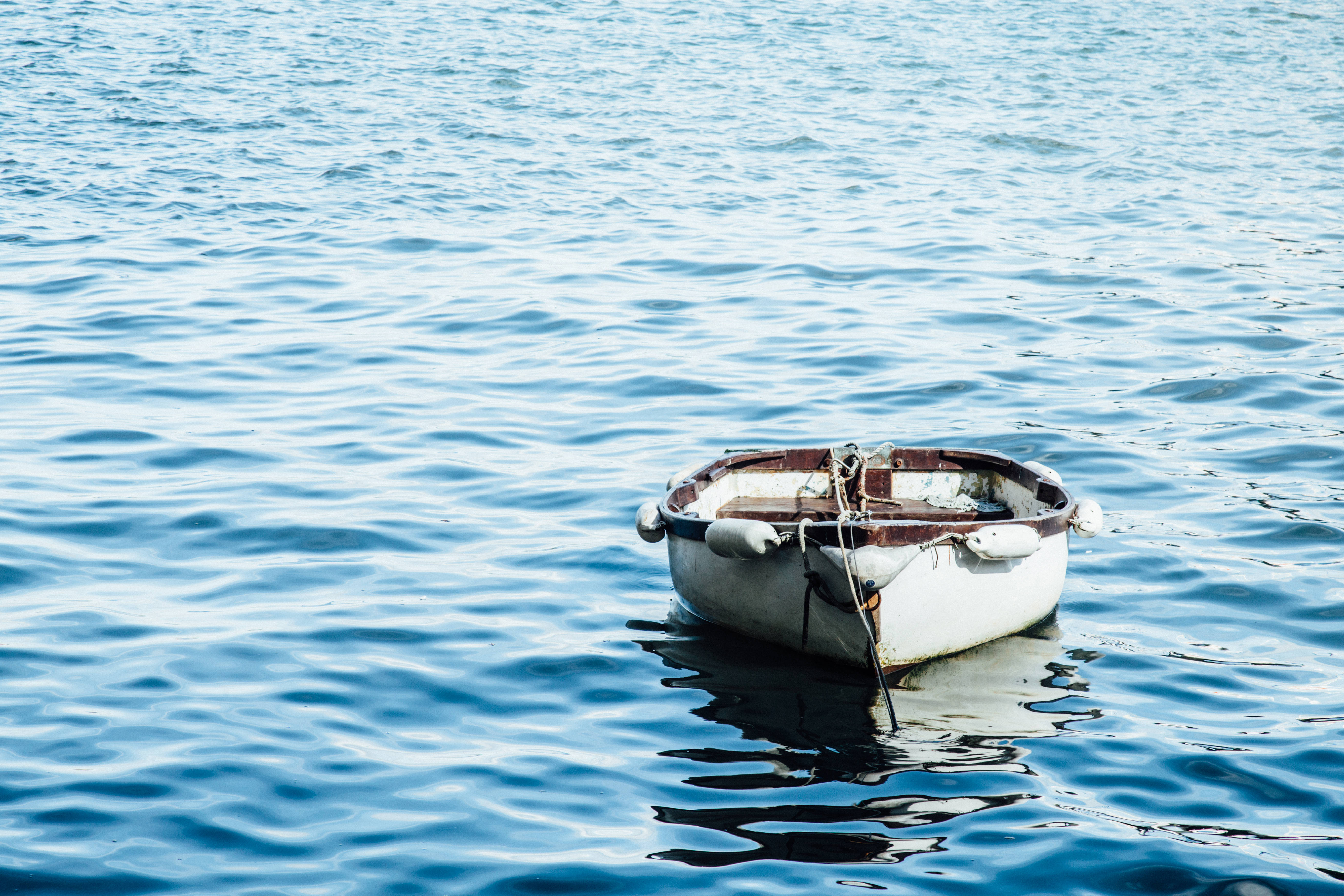small white wooden boat, calm blue water, sunlight, 5K Desktop Wallpaper