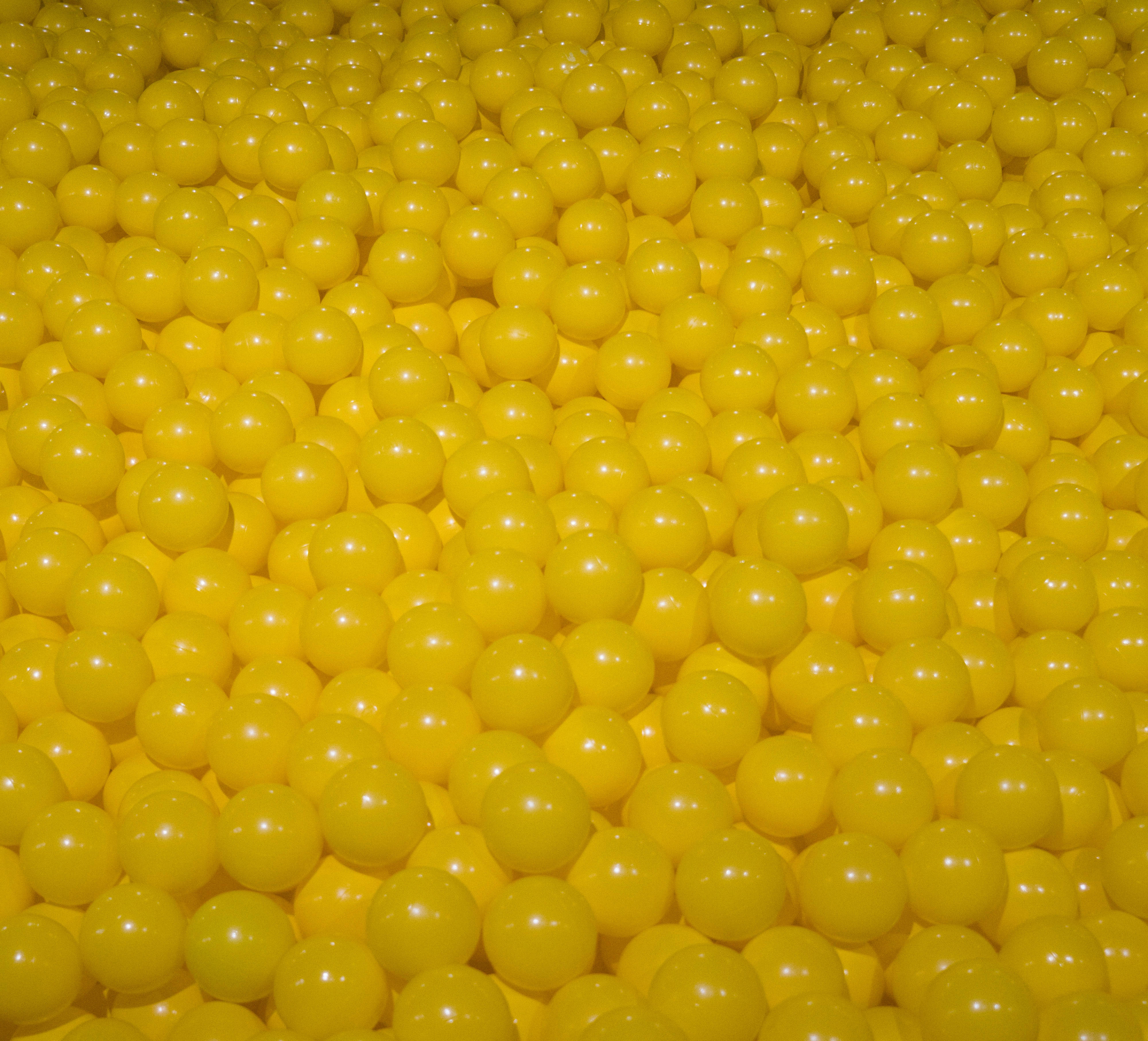 tiny yellow balls, glossy yellow plastic balls, uniform spherical shapes, 4K Desktop Wallpaper