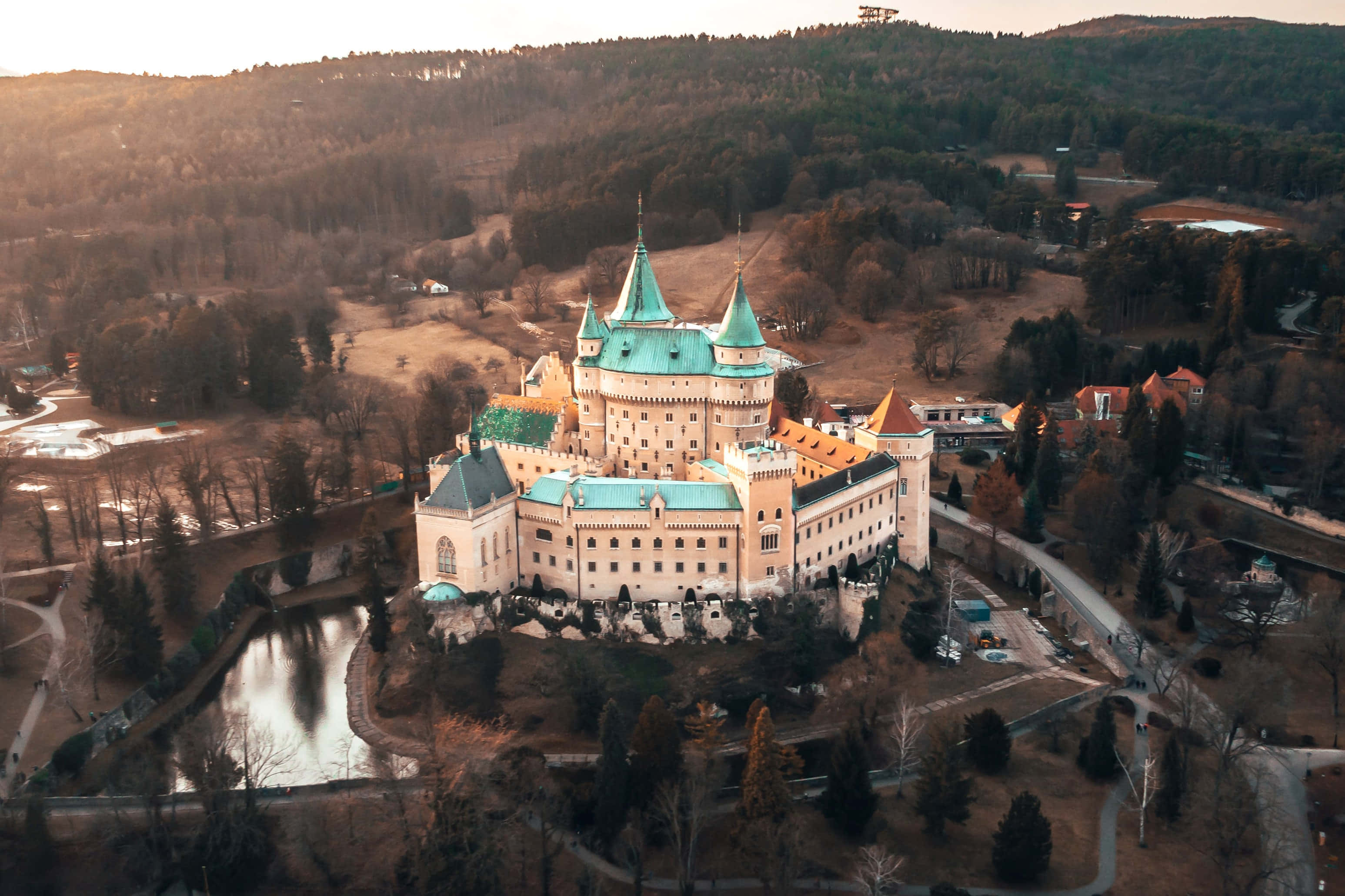 Bojnice Castle, teal roofs, forested valley, 2K Desktop Wallpaper