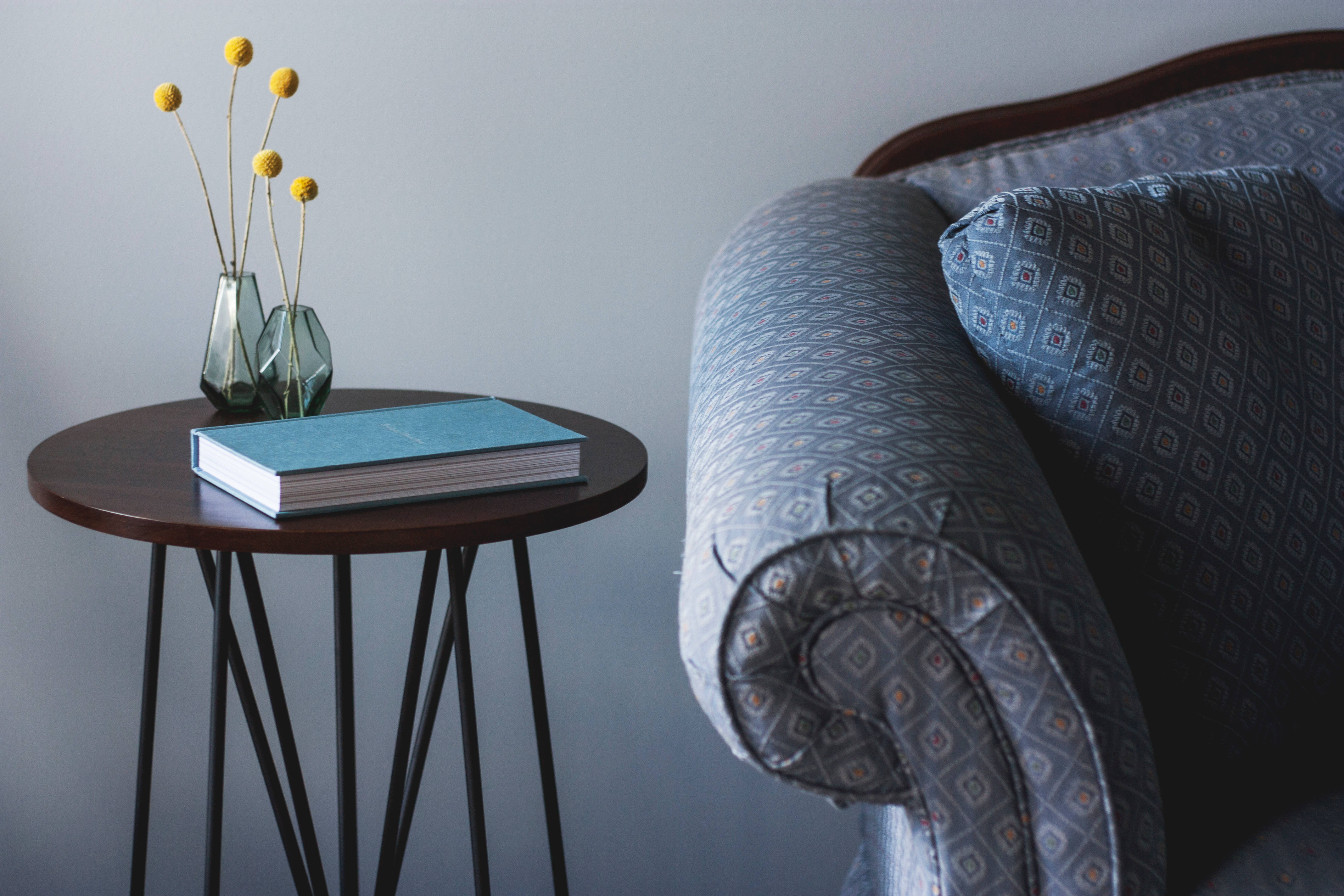 wooden side table, patterned armchair, book, 4K Desktop Wallpaper