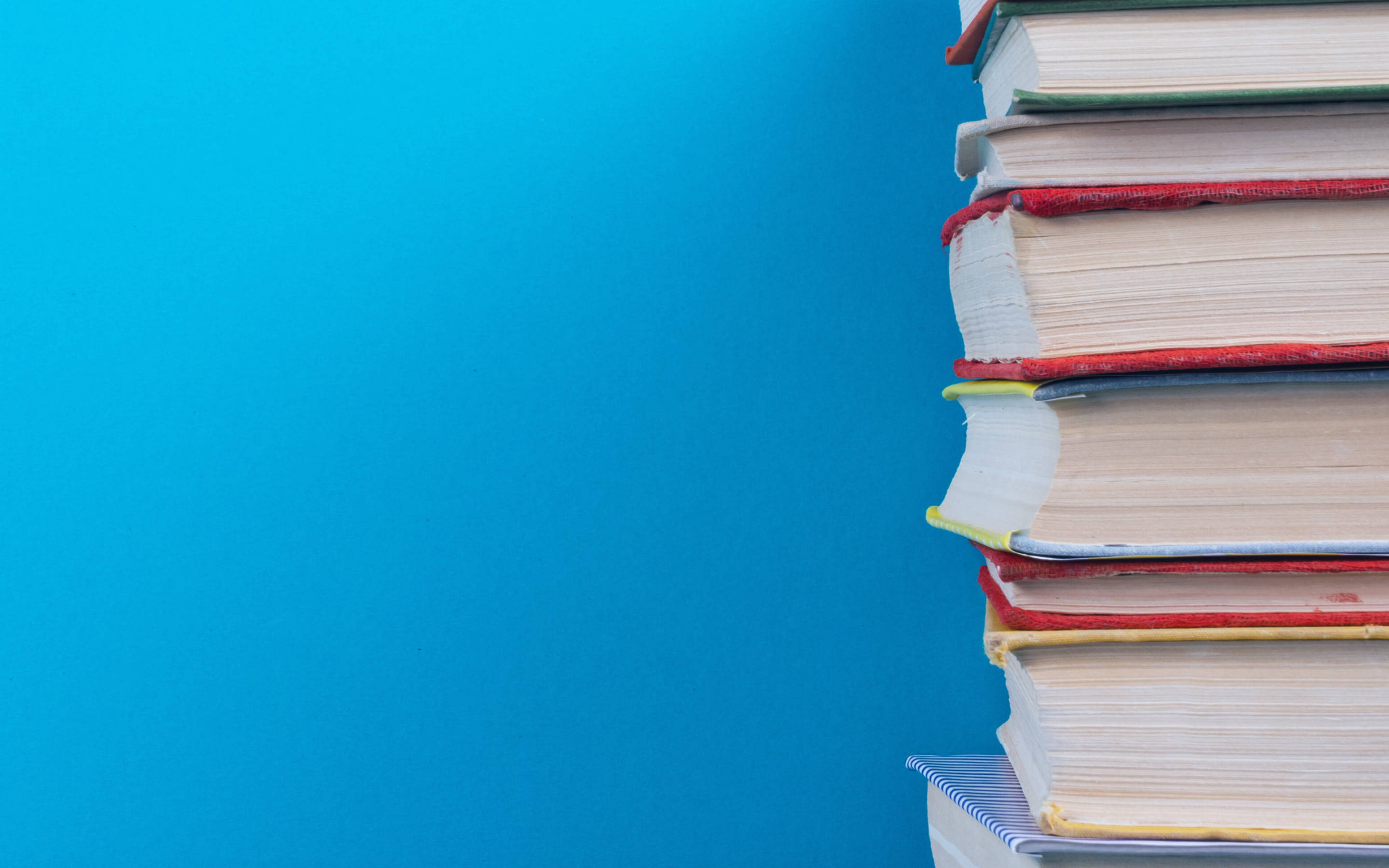 pile of books, blue background, colorful books, 2K Desktop Wallpaper