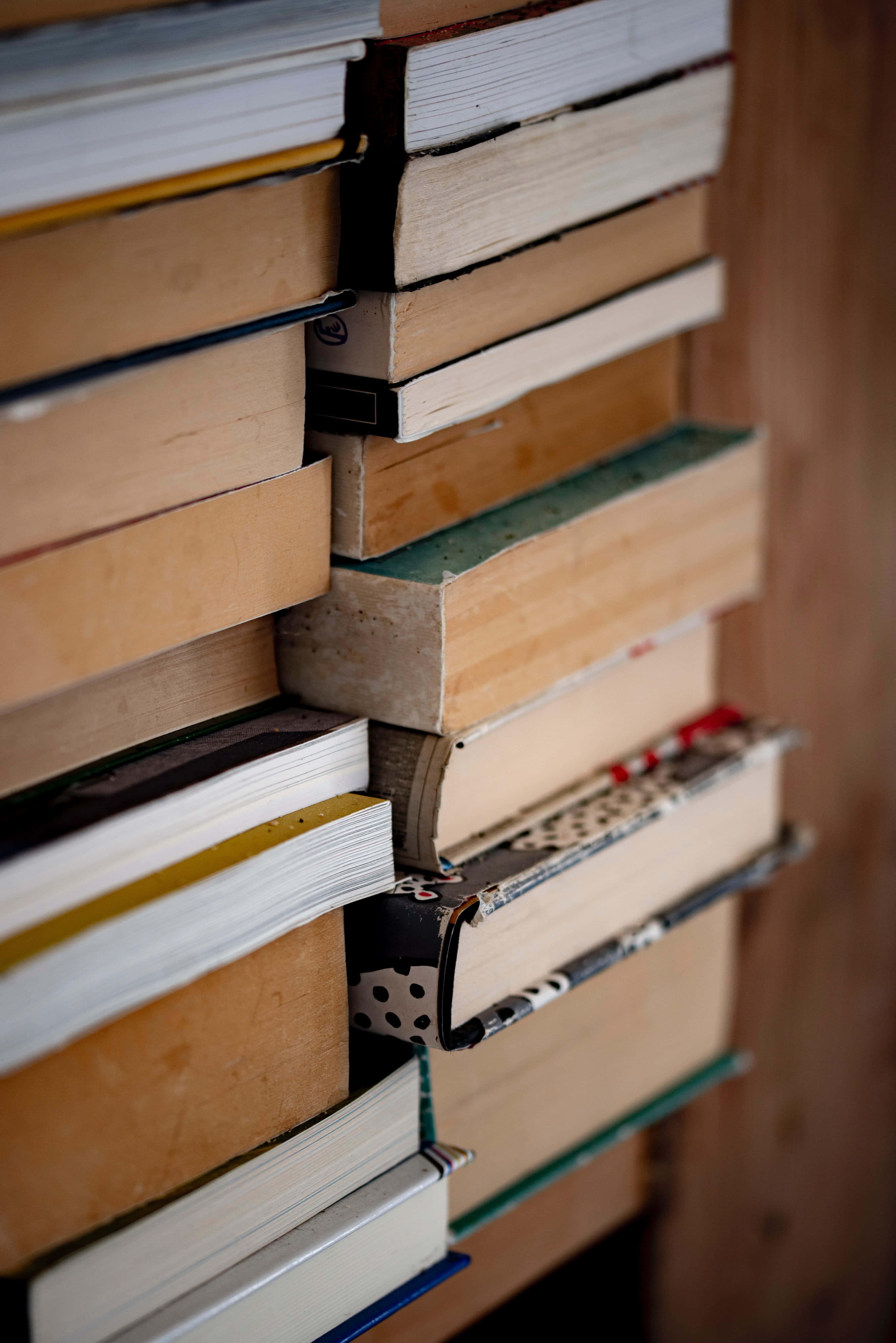 Books iPhone, stacked books, varied spines, 5K Phone Wallpaper