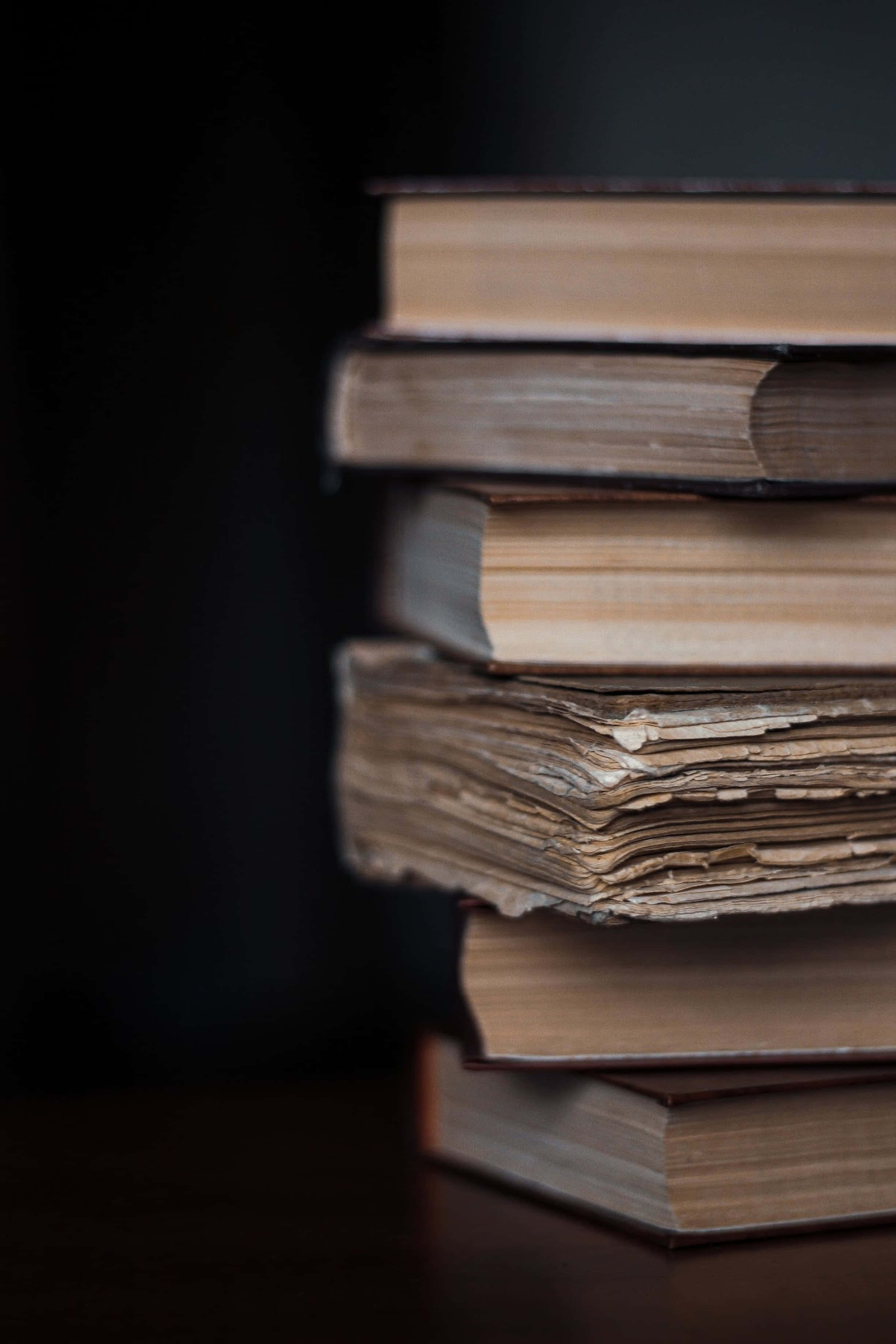 books, table, dark background, 2K Phone Wallpaper