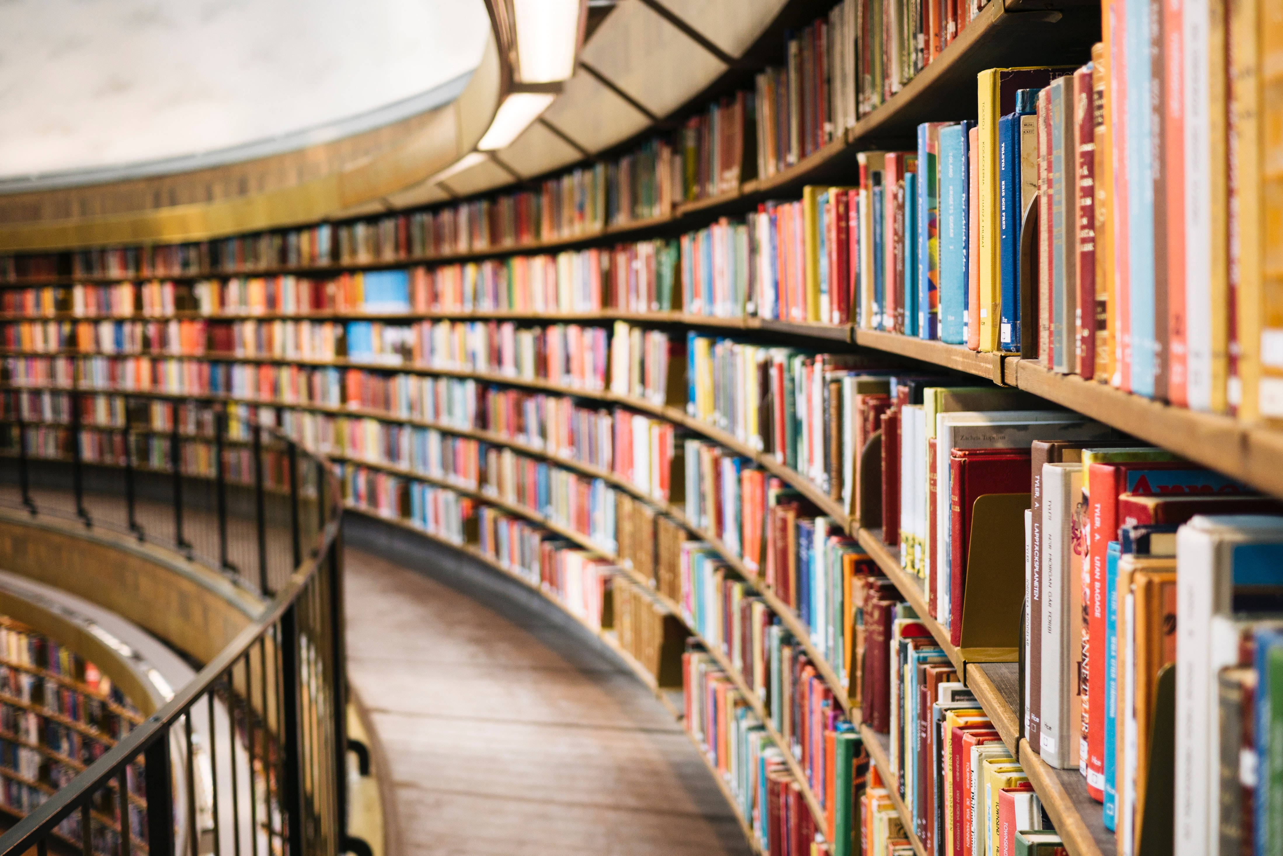 spiral staircase, towering bookshelves, colorful books, 4K Desktop Wallpaper