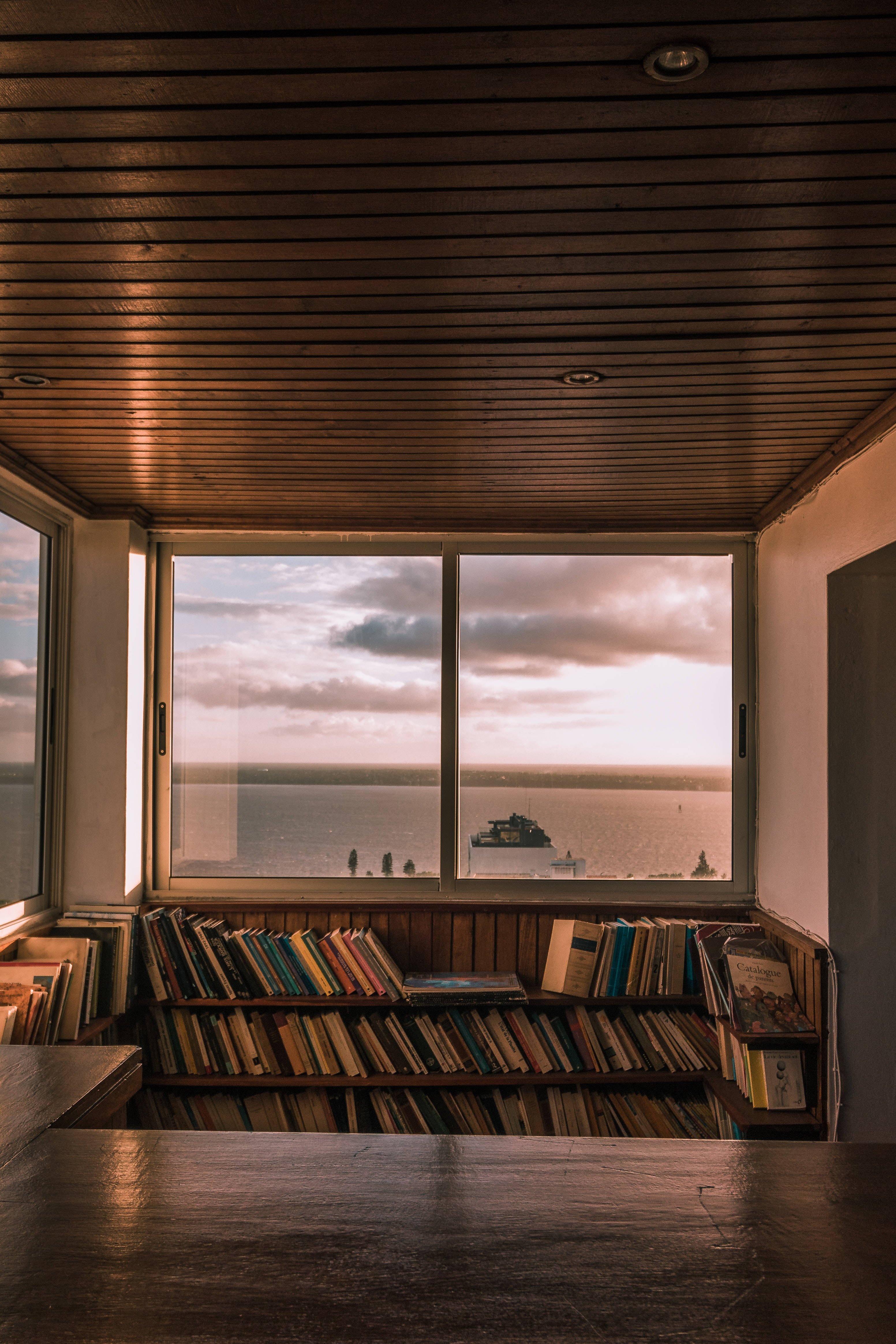 chic and minimalist library, warm wooden interior, bookshelves, 4K Phone Wallpaper