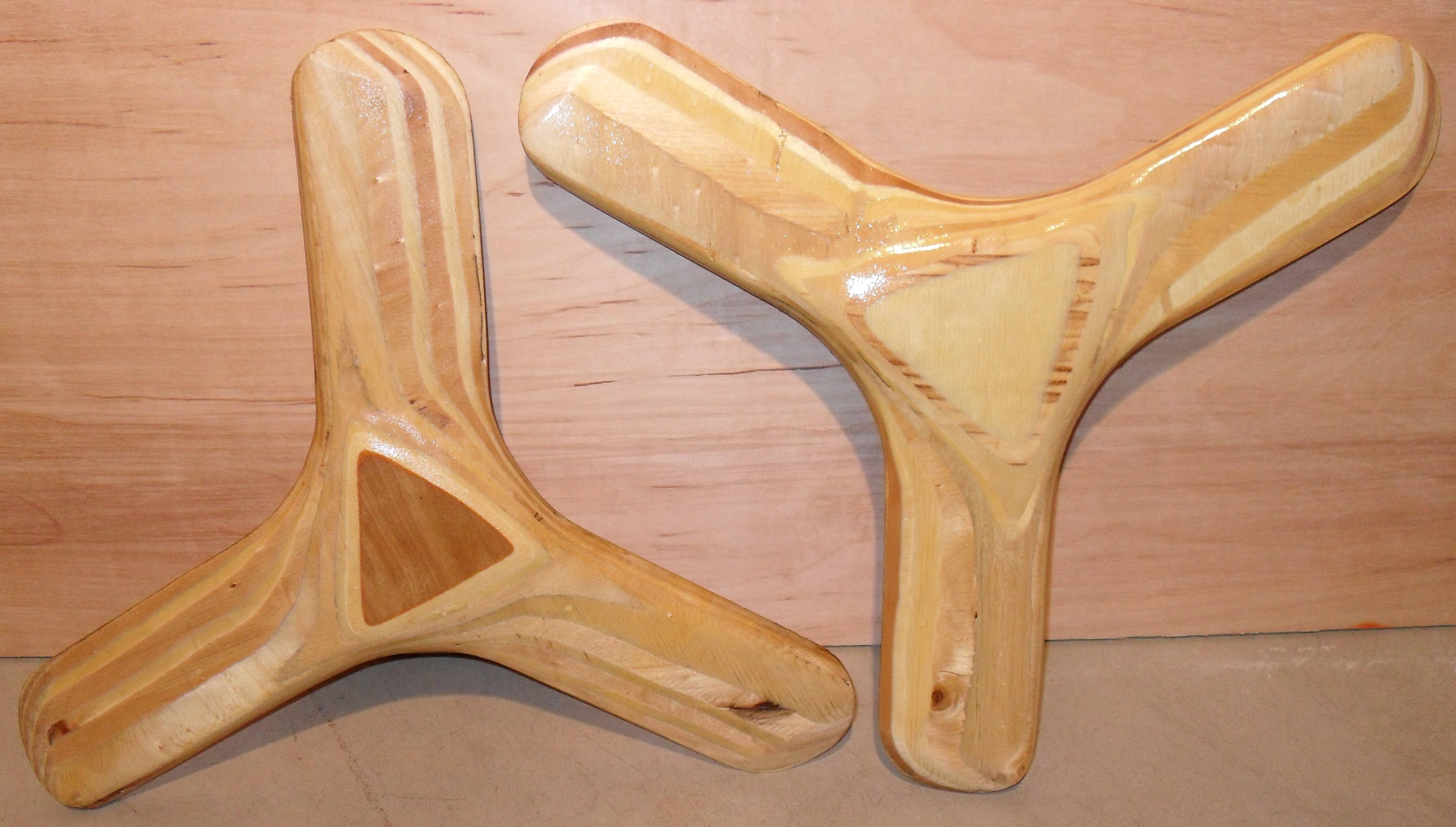 two wooden boomerangs, handcrafted wooden boomerangs, natural grain patterns, 2K Desktop Wallpaper