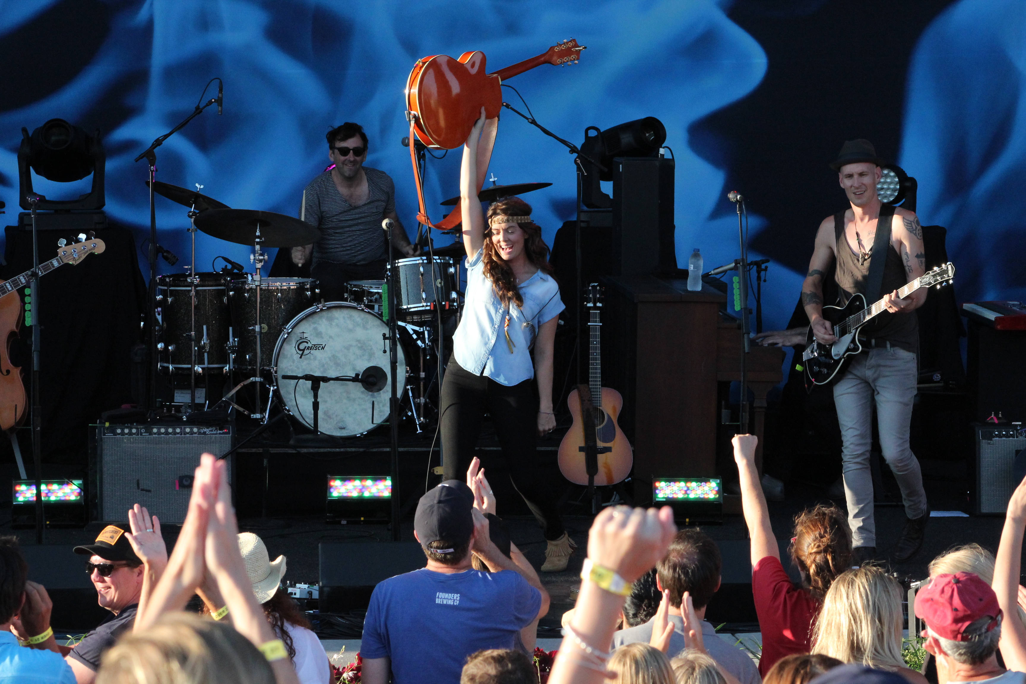 Brandi Carlile, giant orange guitar, vibrant outdoor concert stage, 2K Desktop Wallpaper