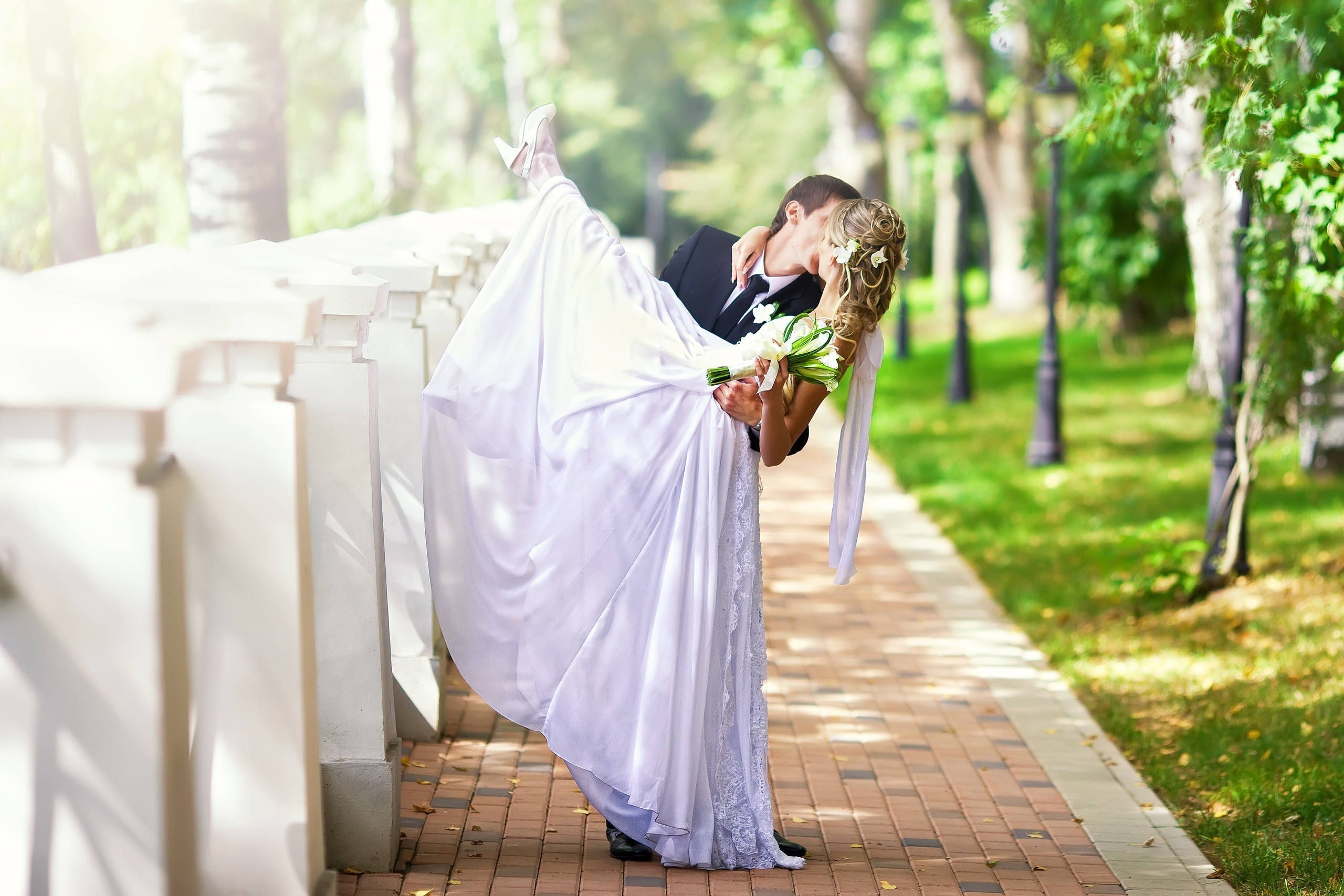 Romantic Bridal Kiss, sunlit cemetery path, white headstones, 2K Desktop Wallpaper