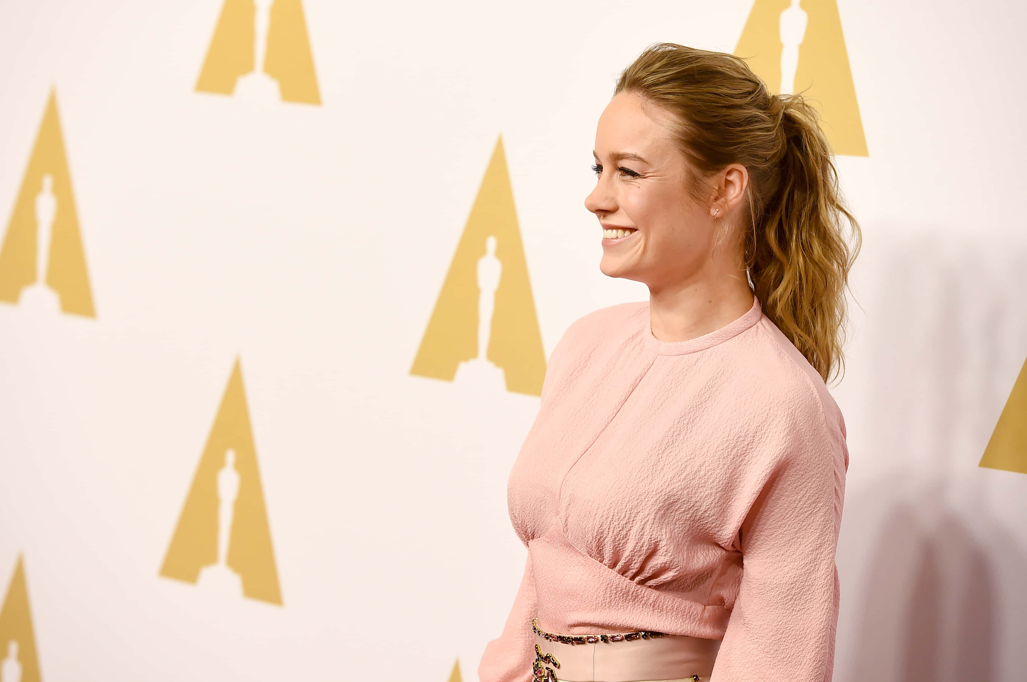 Brie Larson, pink top, white wall, 2K Desktop Wallpaper