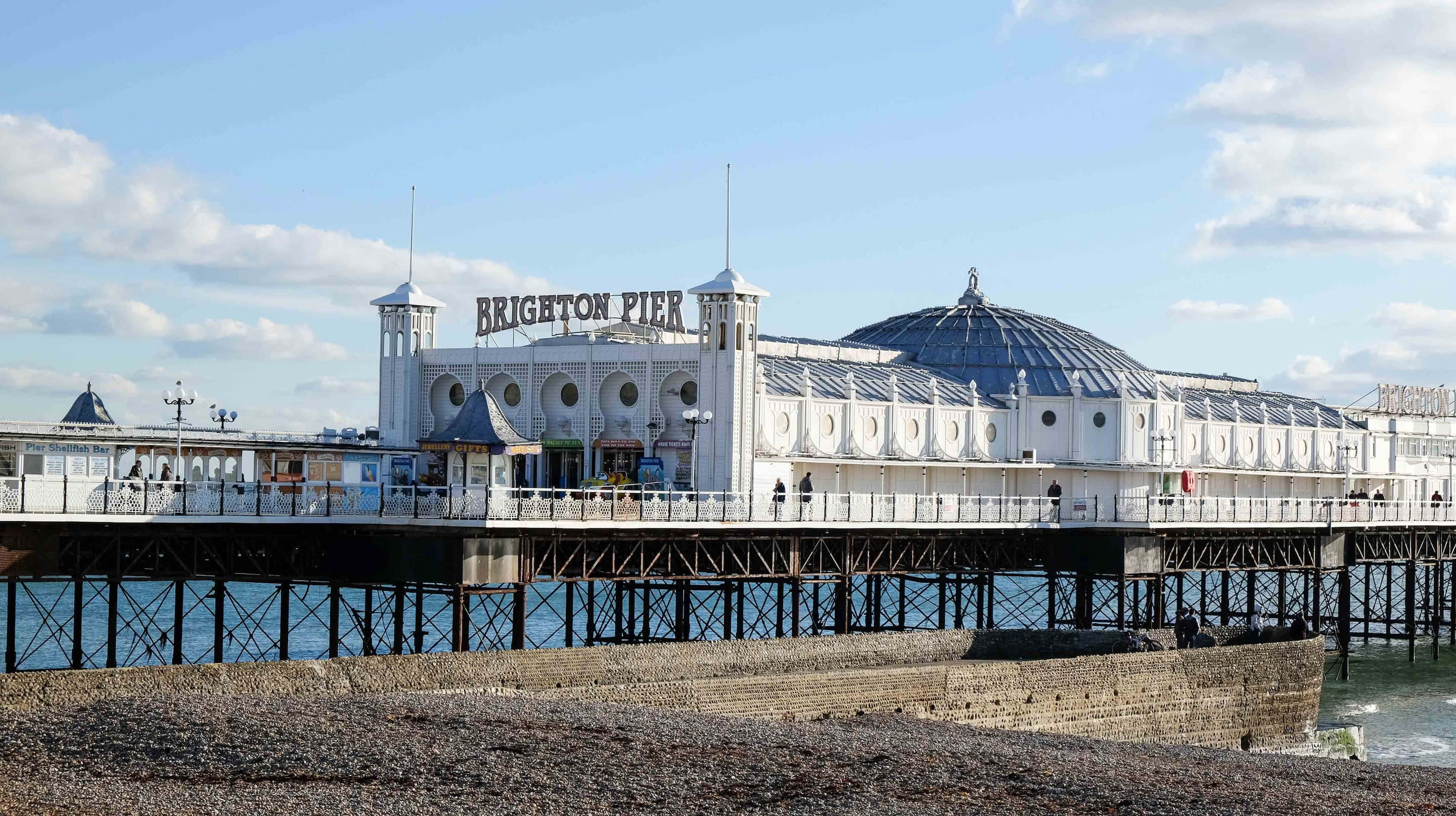 Brighton Pier, calm blue sea, partly cloudy sky, 2K Desktop Wallpaper