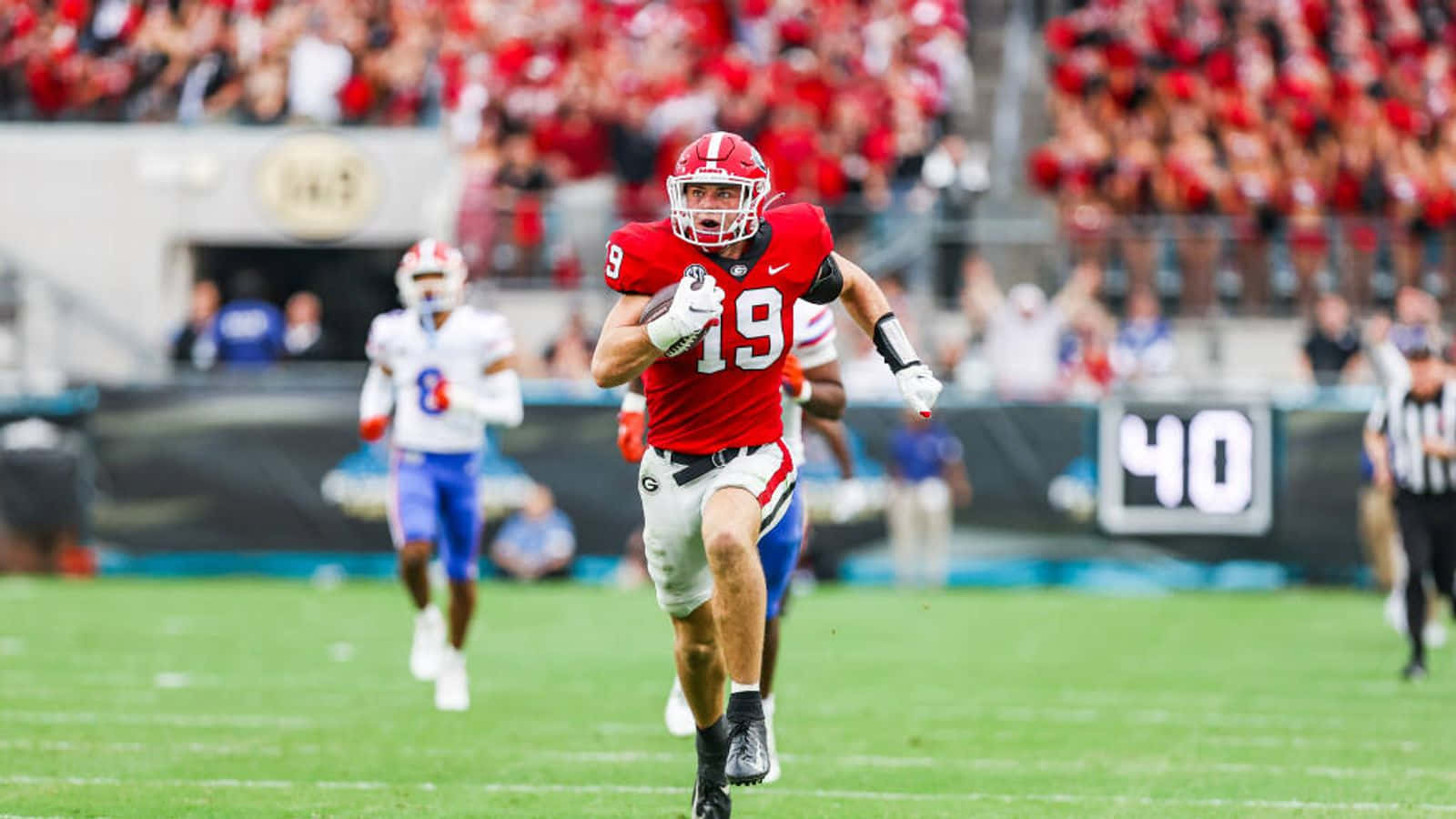 Brock Bowers, red jersey number 19, green field, HD Desktop Wallpaper