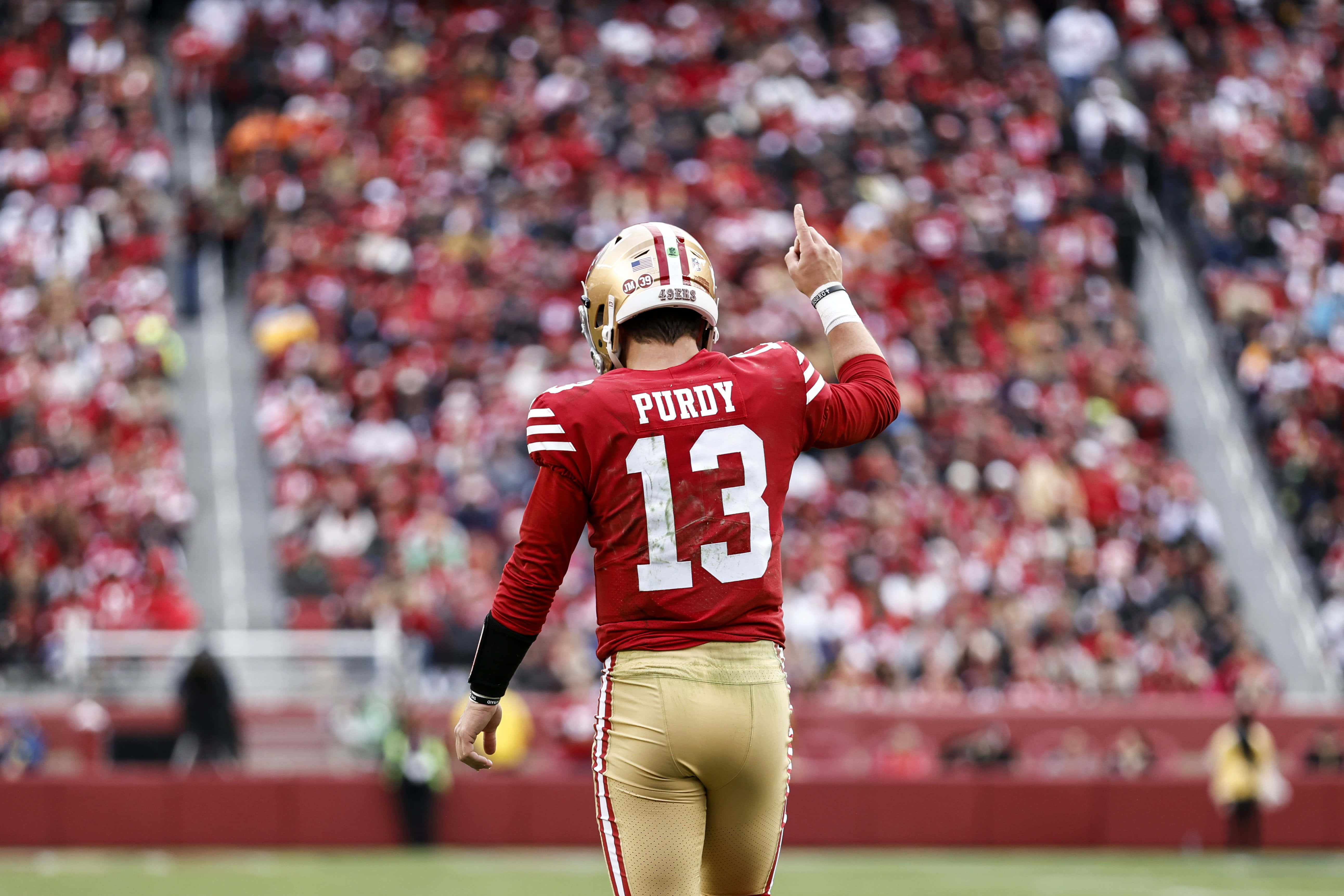 Brock Purdy, red and gold uniform, sunlit field, 5K Desktop Wallpaper