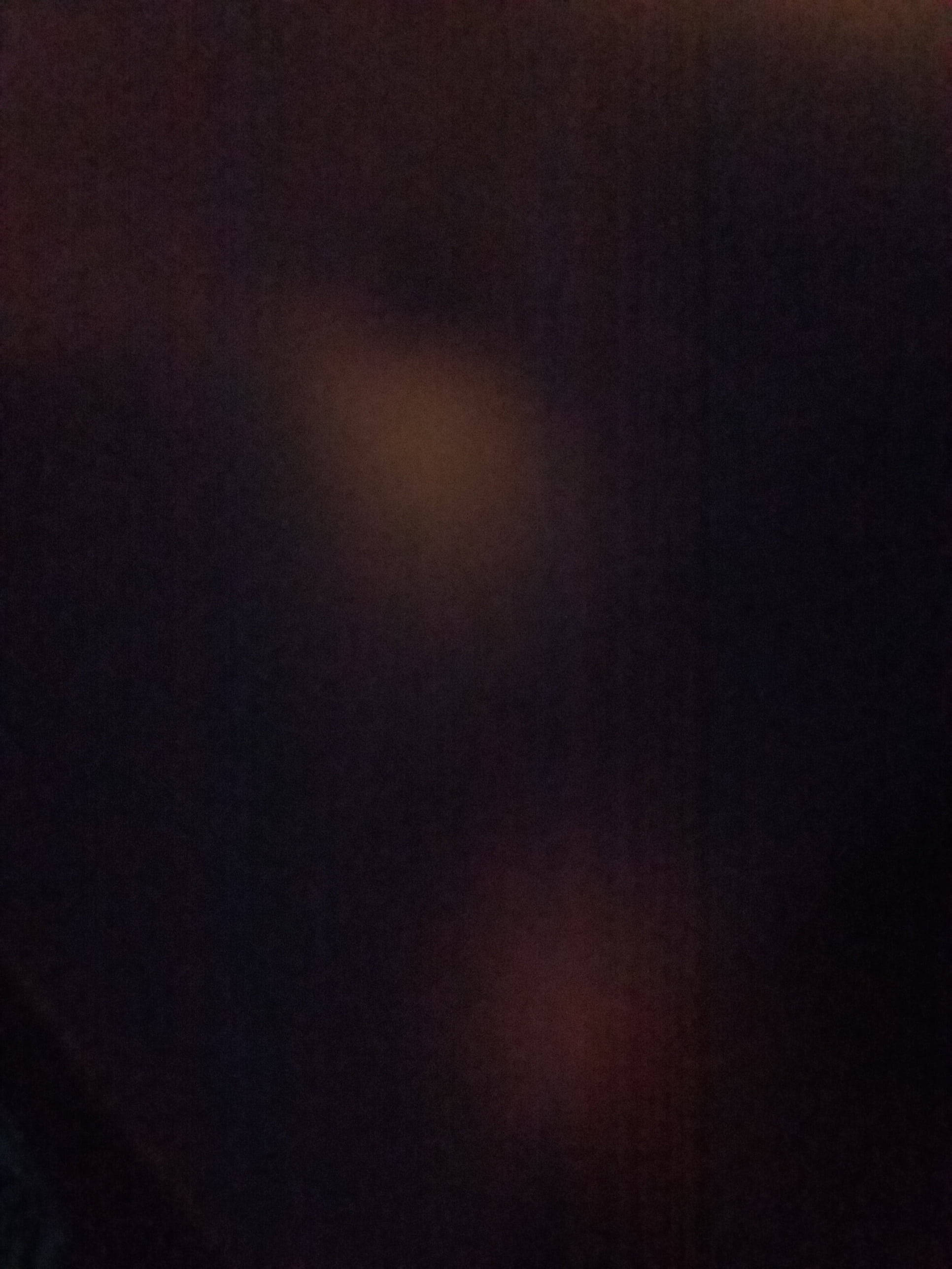 stained total black abstract phone, soft blurred warm light spots, deep shadowy background, 2K Phone Wallpaper