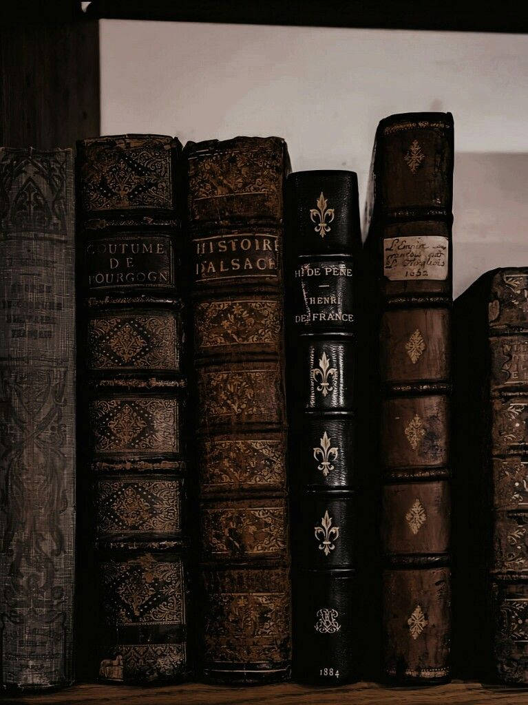 antique leather-bound books, gold embossing, dim light, SD Phone Wallpaper