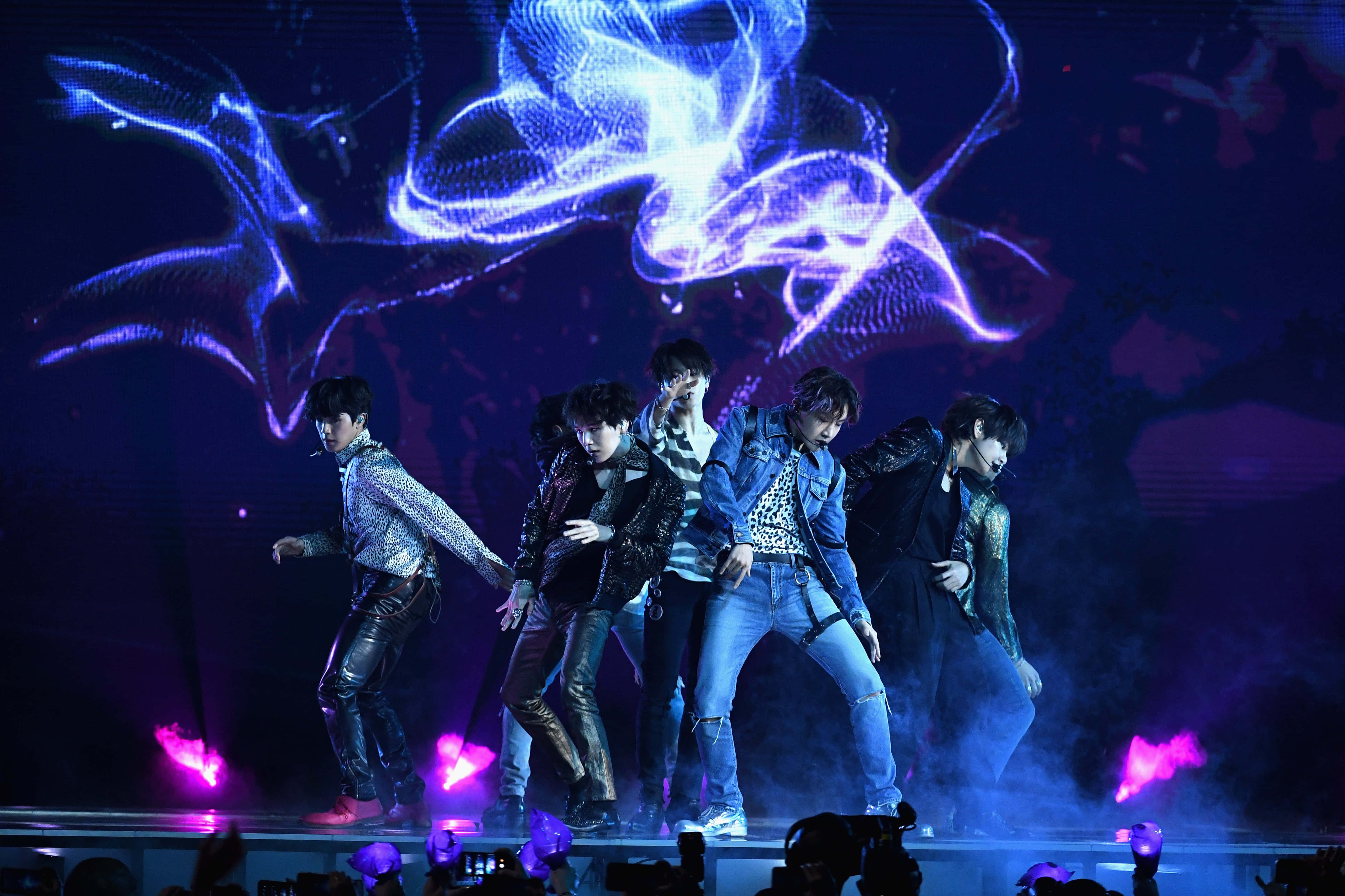 BTS Performance, glowing blue and purple stage lights, swirling digital projections, 4K Desktop Wallpaper