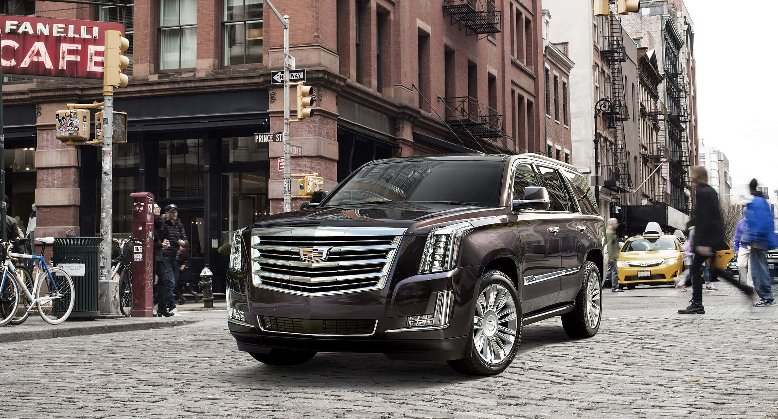 Cadillac Escalade, dark brown, cobblestone city street, 2K Desktop Wallpaper