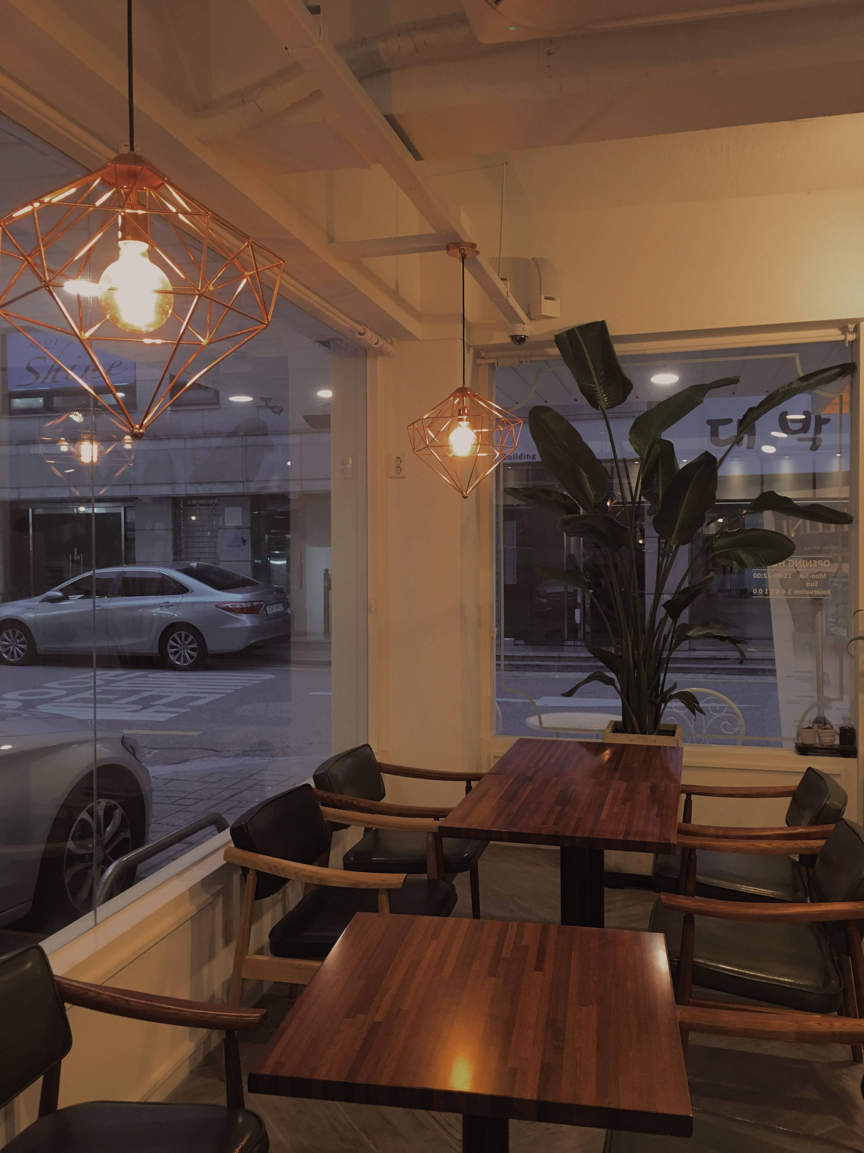 cozy café, warm pendant lights, wooden tables, 4K Phone Wallpaper