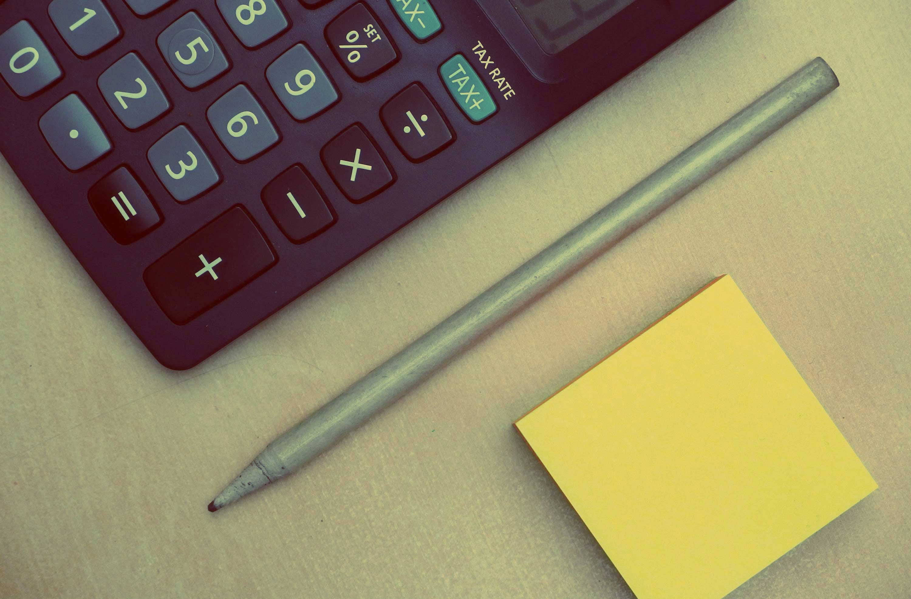 maroon calculator, yellow sticky note, beige desk surface, 2K Desktop Wallpaper