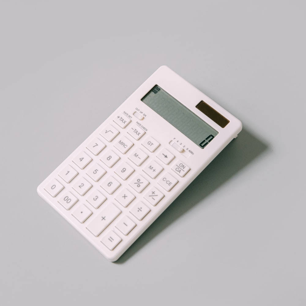 plain white calculator, sleek white calculator, muted gray surface, SD Desktop Wallpaper