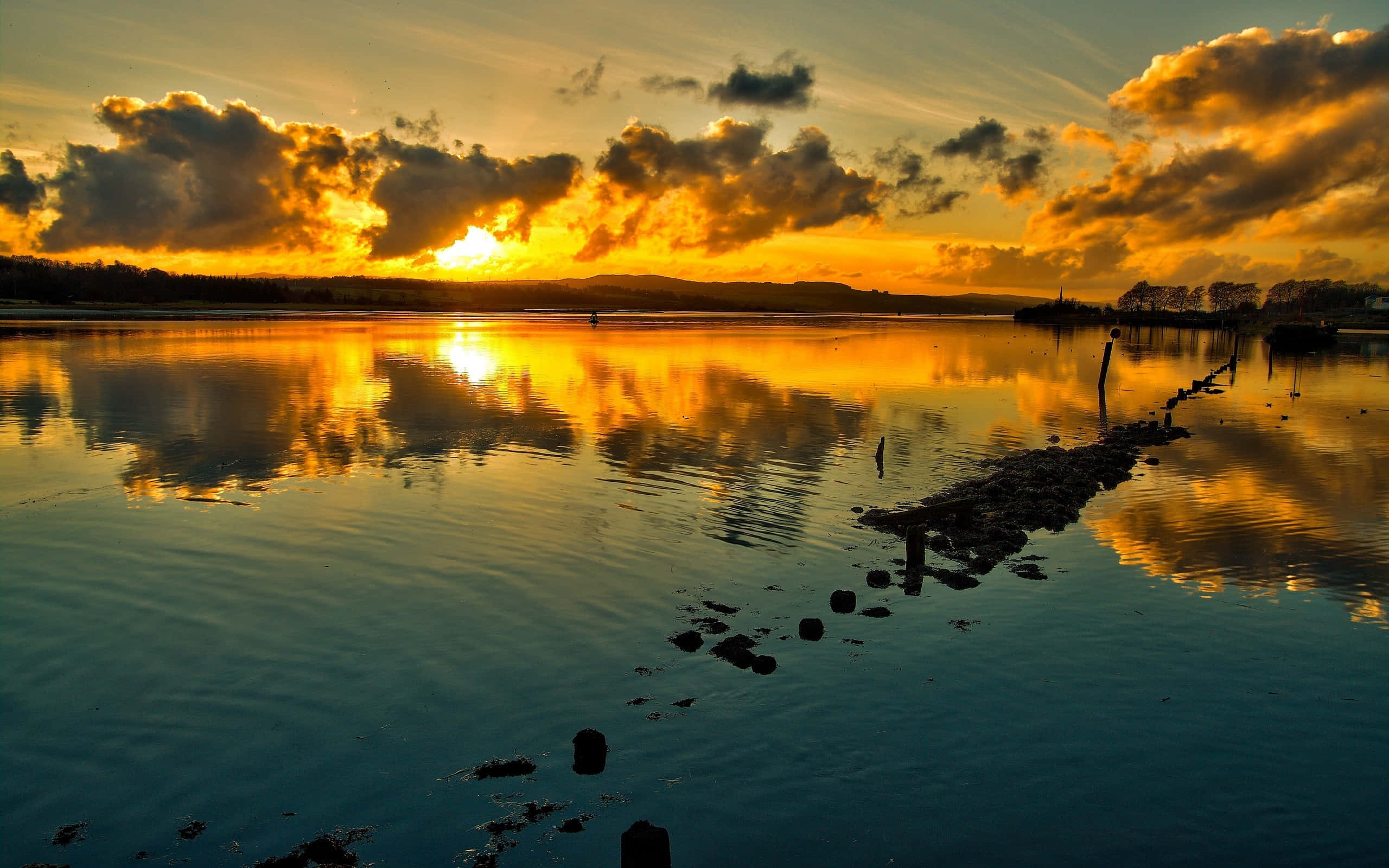 Golden sunset, calm water, dramatic clouds, 2K Desktop Wallpaper