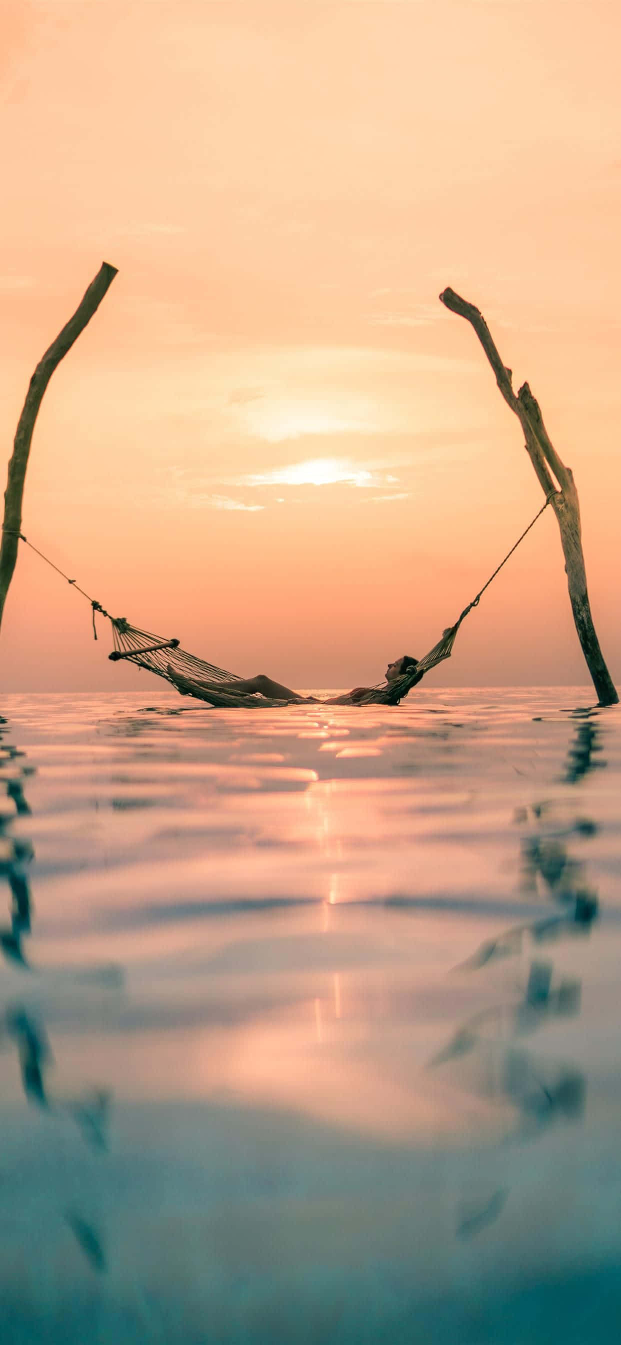 sunset, calm water, warm orange and pink hues, 2K Phone Wallpaper