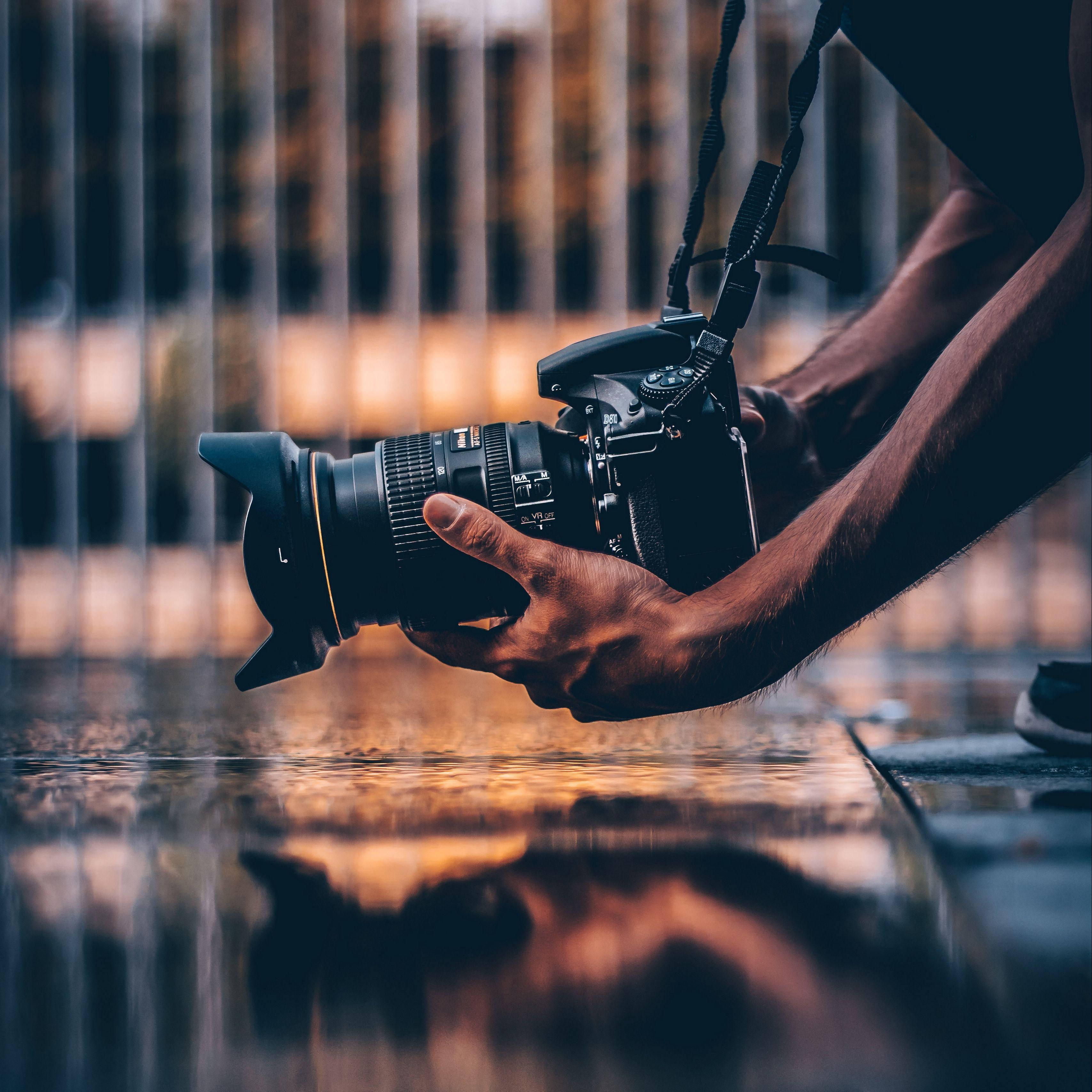DSLR camera, rain-slicked pavement, warm golden city lights, 2K Desktop Wallpaper