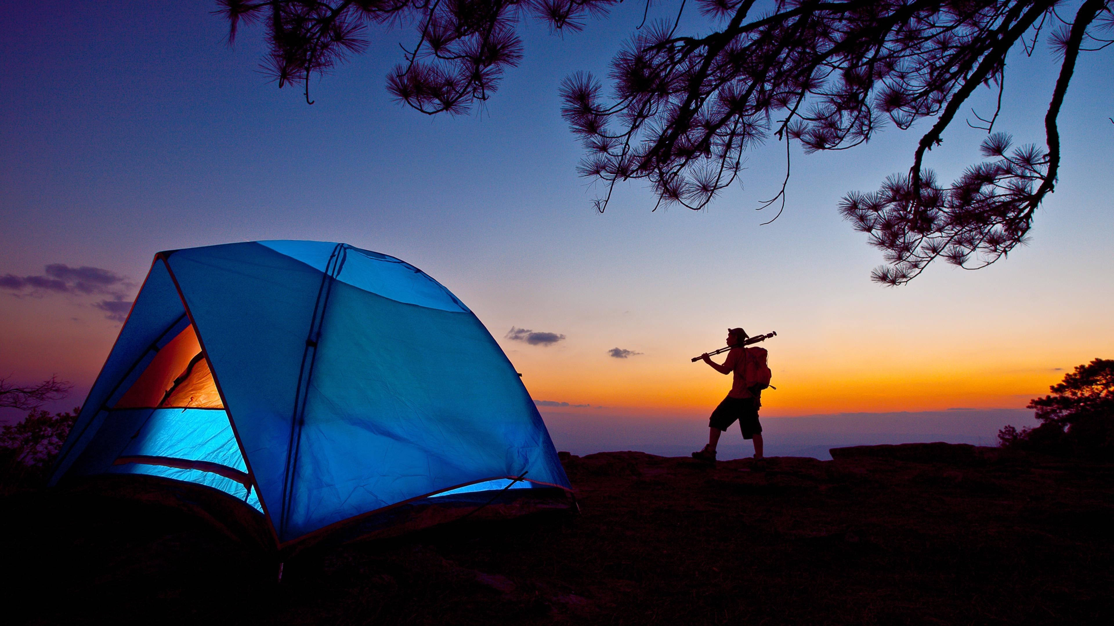 Camping Man Silhouette, vibrant sunset, glowing blue tent, 4K Desktop Wallpaper