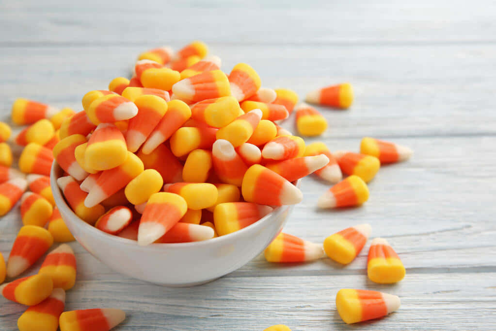bowlof candy cornon wooden table, white bowl, candy corn, SD Desktop Wallpaper