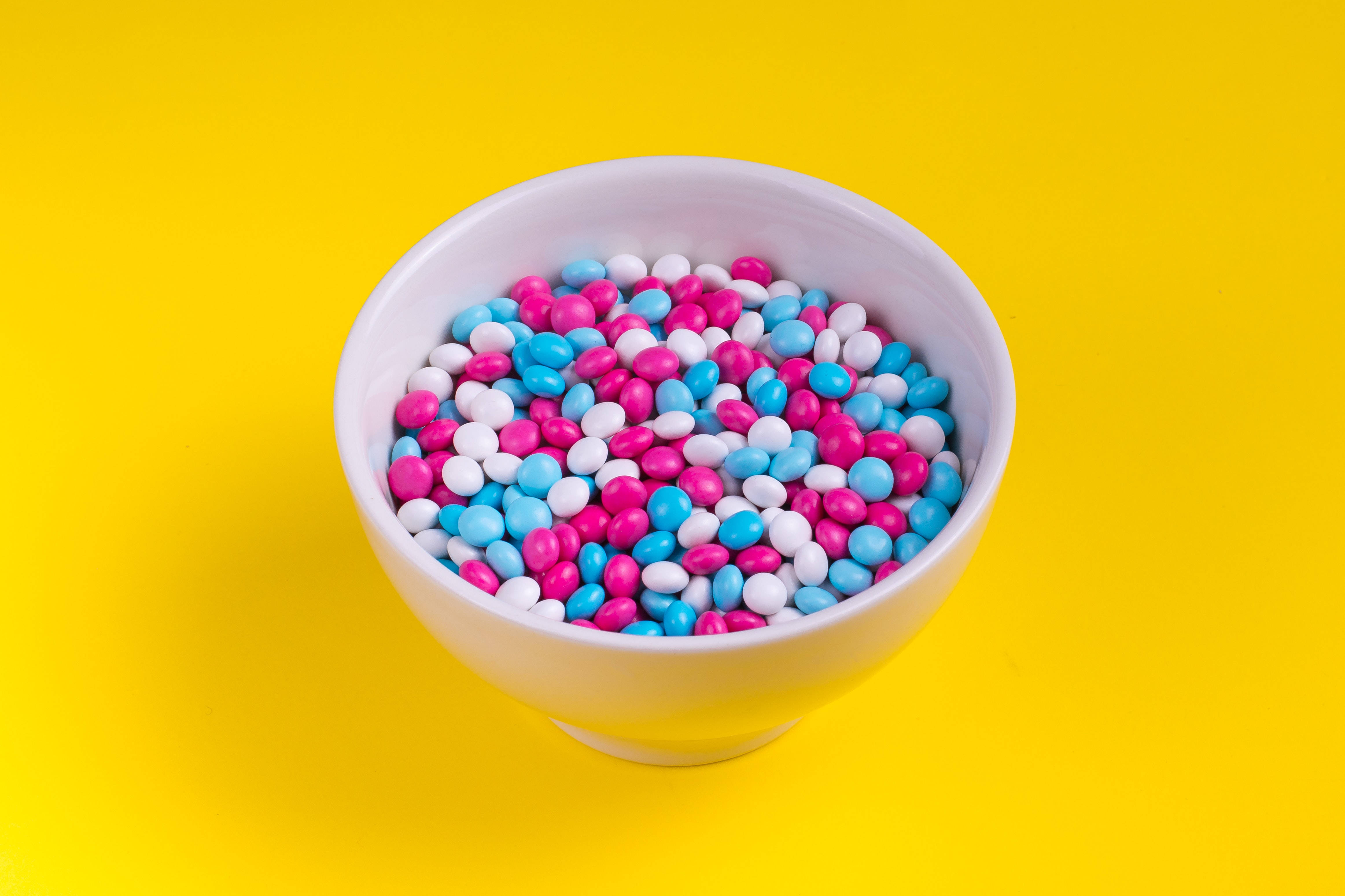 solid pastel color candy chocolate, white bowl, vibrant pink blue and white candy-coated chocolates, 4K Desktop Wallpaper