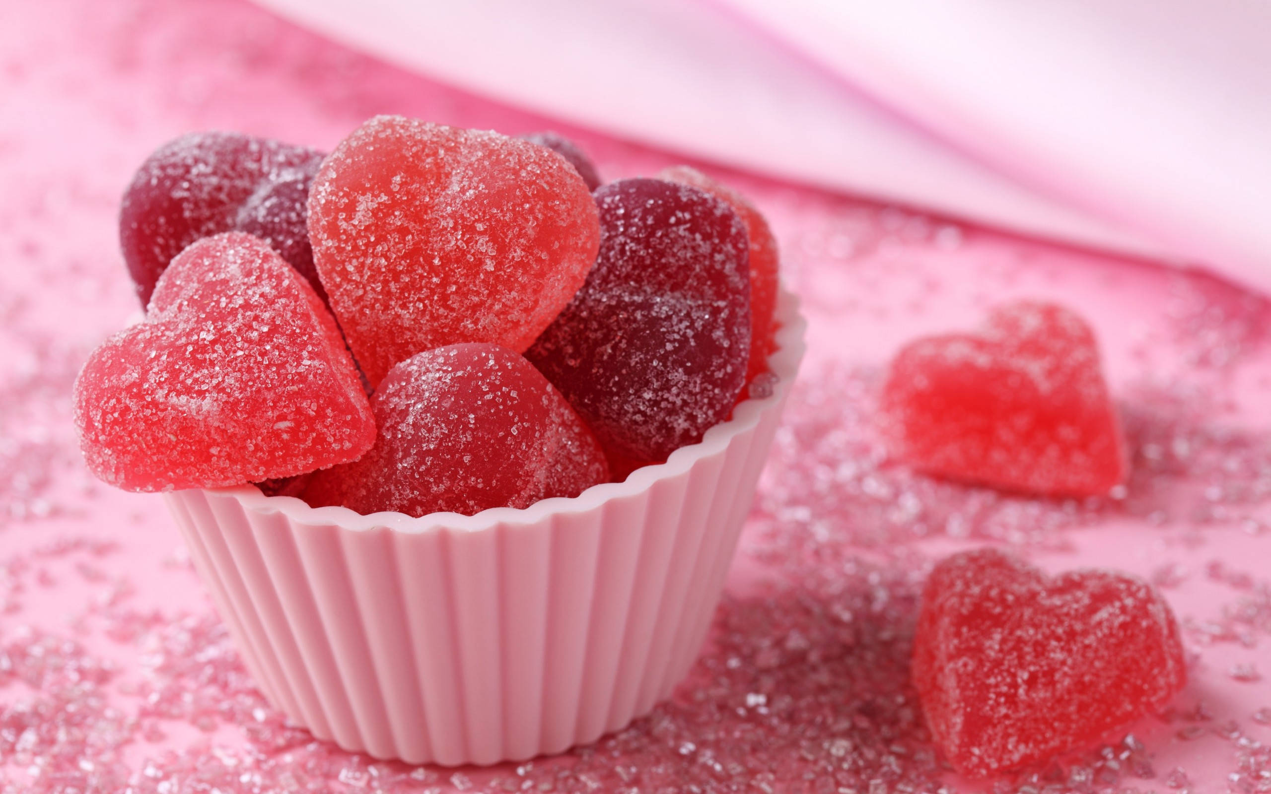 pink heart gummy candies, fluted pink cup, glistening red heart-shaped gummy candies, 2K Desktop Wallpaper
