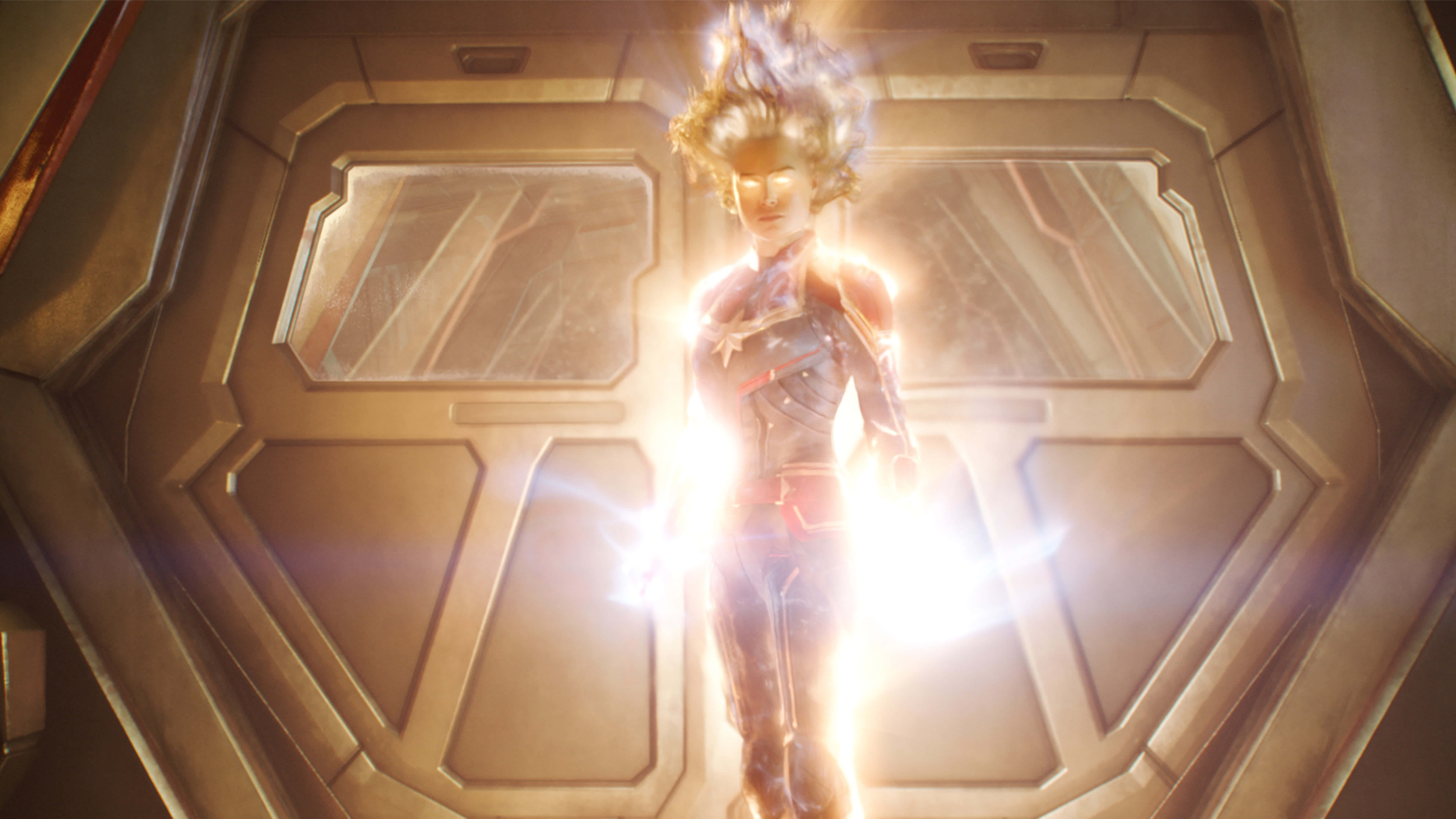 Captain Marvel, glowing suit, futuristic spaceship doorway, 8K Desktop Wallpaper