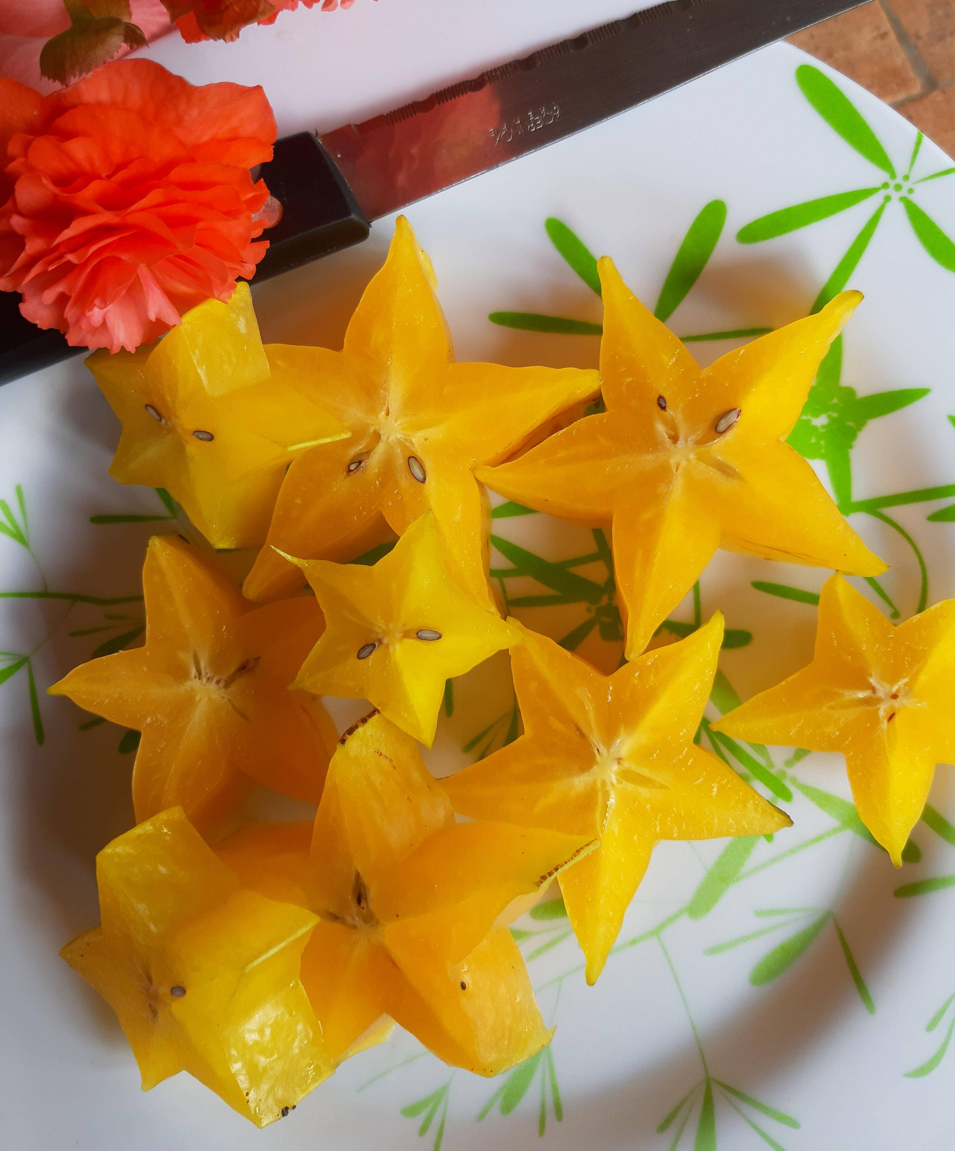 Golden Star Carambola, yellow starfruit slices, green-patterned plate, 2K Phone Wallpaper