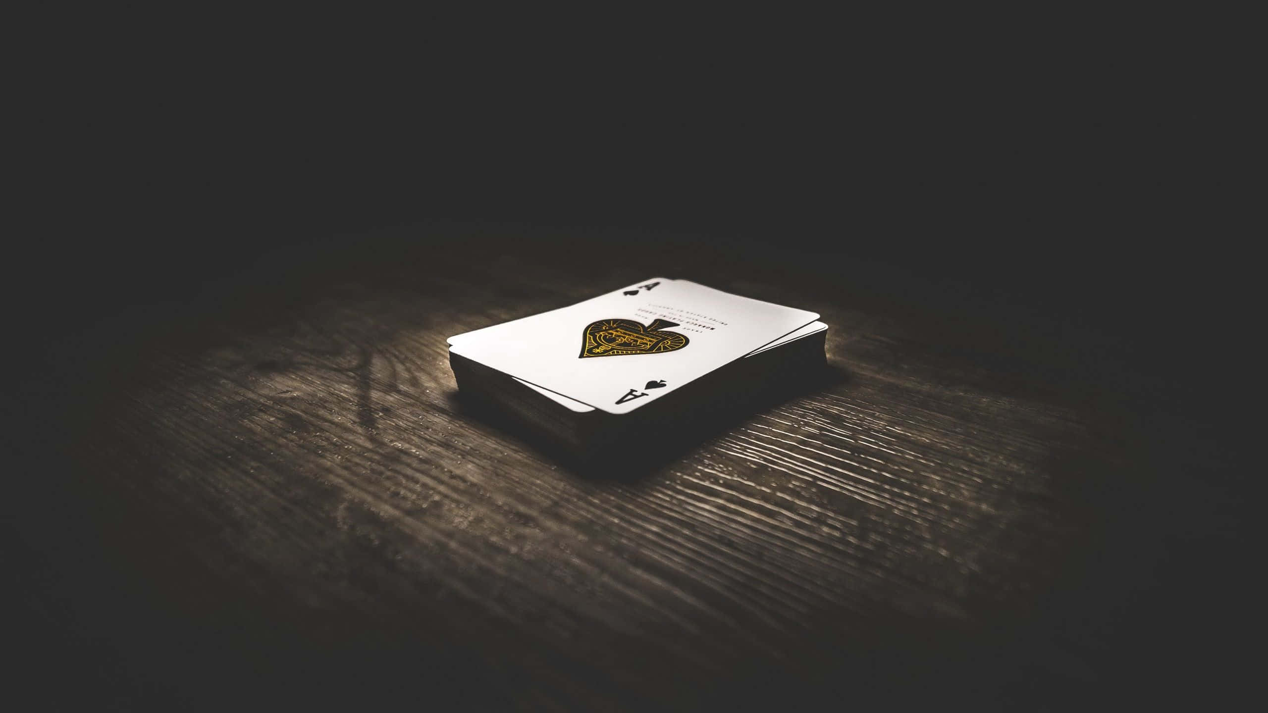 playing cards, dark wooden table, dramatic spotlight lighting, 2K Desktop Wallpaper