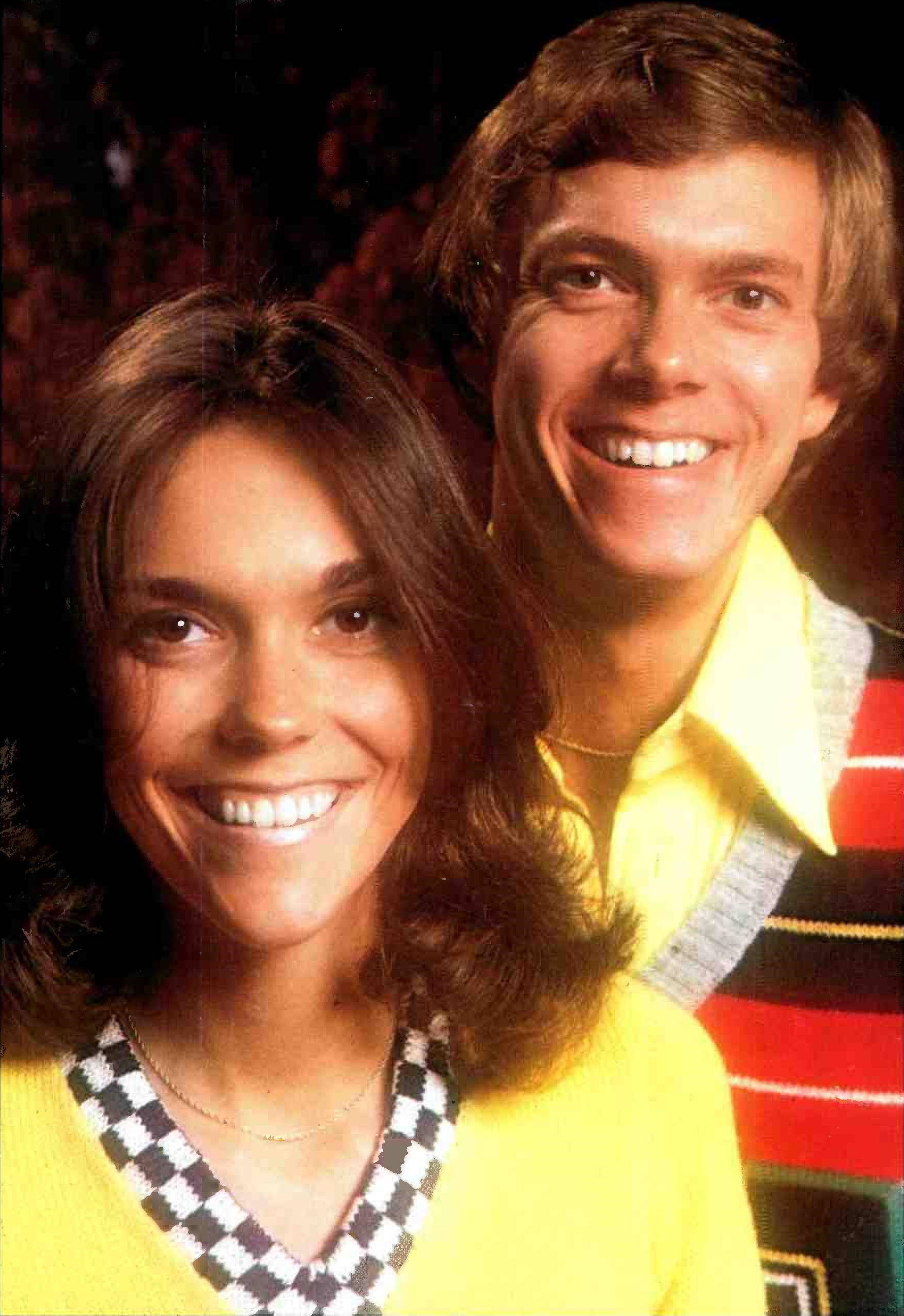1970s couple, bright yellow sweaters, dark background, Full HD Phone Wallpaper