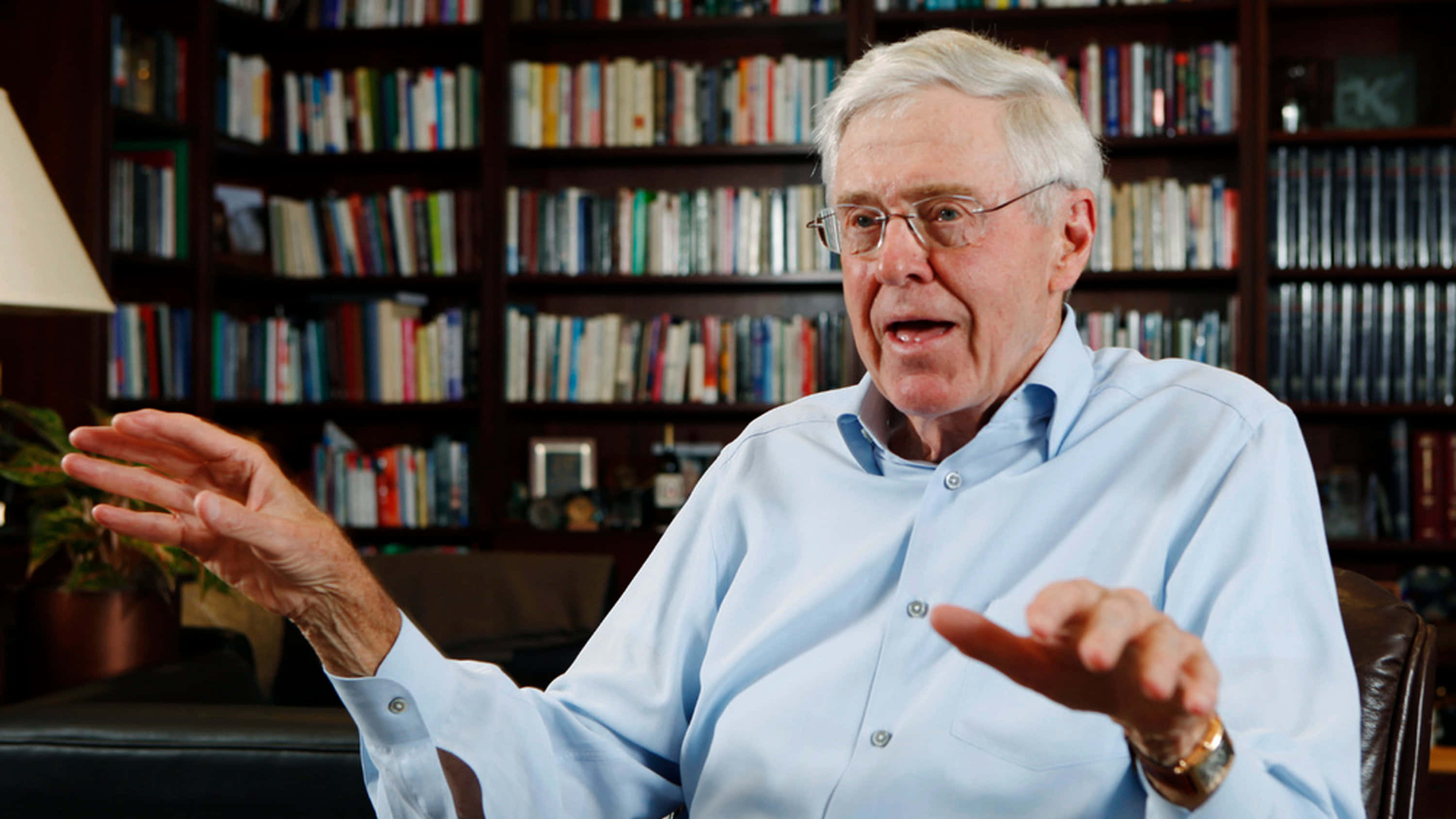 Charles G. Koch, leather chair, towering bookshelf, 2K Desktop Wallpaper