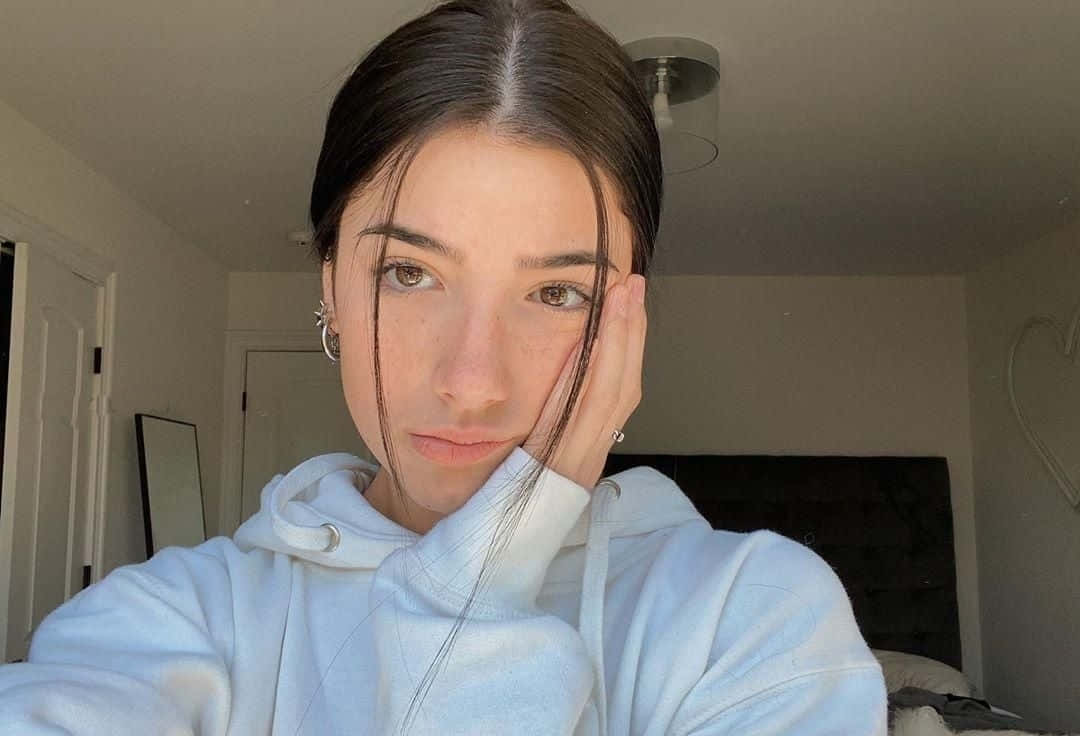 Charlie Damelio, white hoodie, softly lit bedroom, SD Desktop Wallpaper
