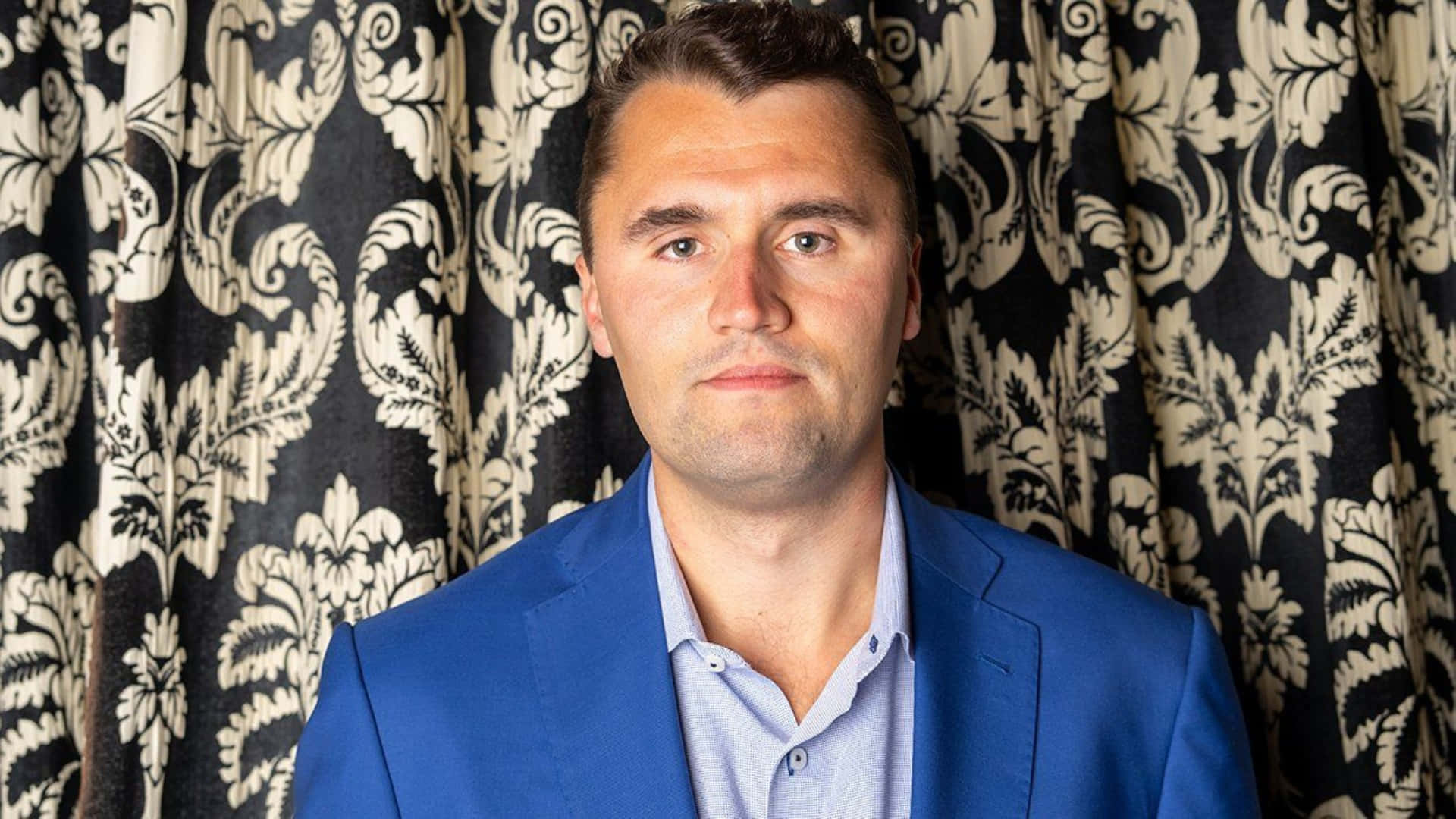Charlie Kirk, blue suit, black and white floral curtains, Full HD Desktop Wallpaper