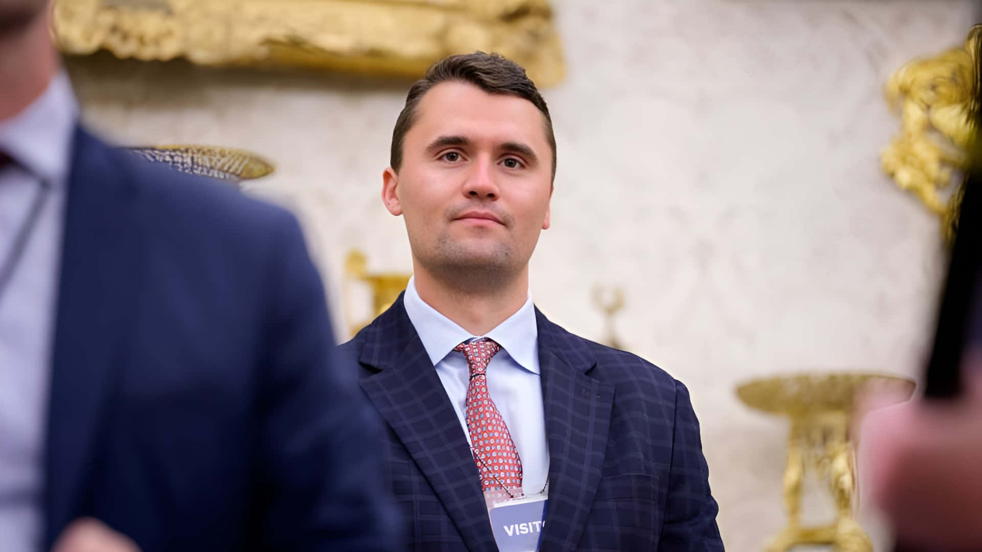 Charlie Kirk, dark checkered suit, red patterned tie, Full HD Desktop Wallpaper