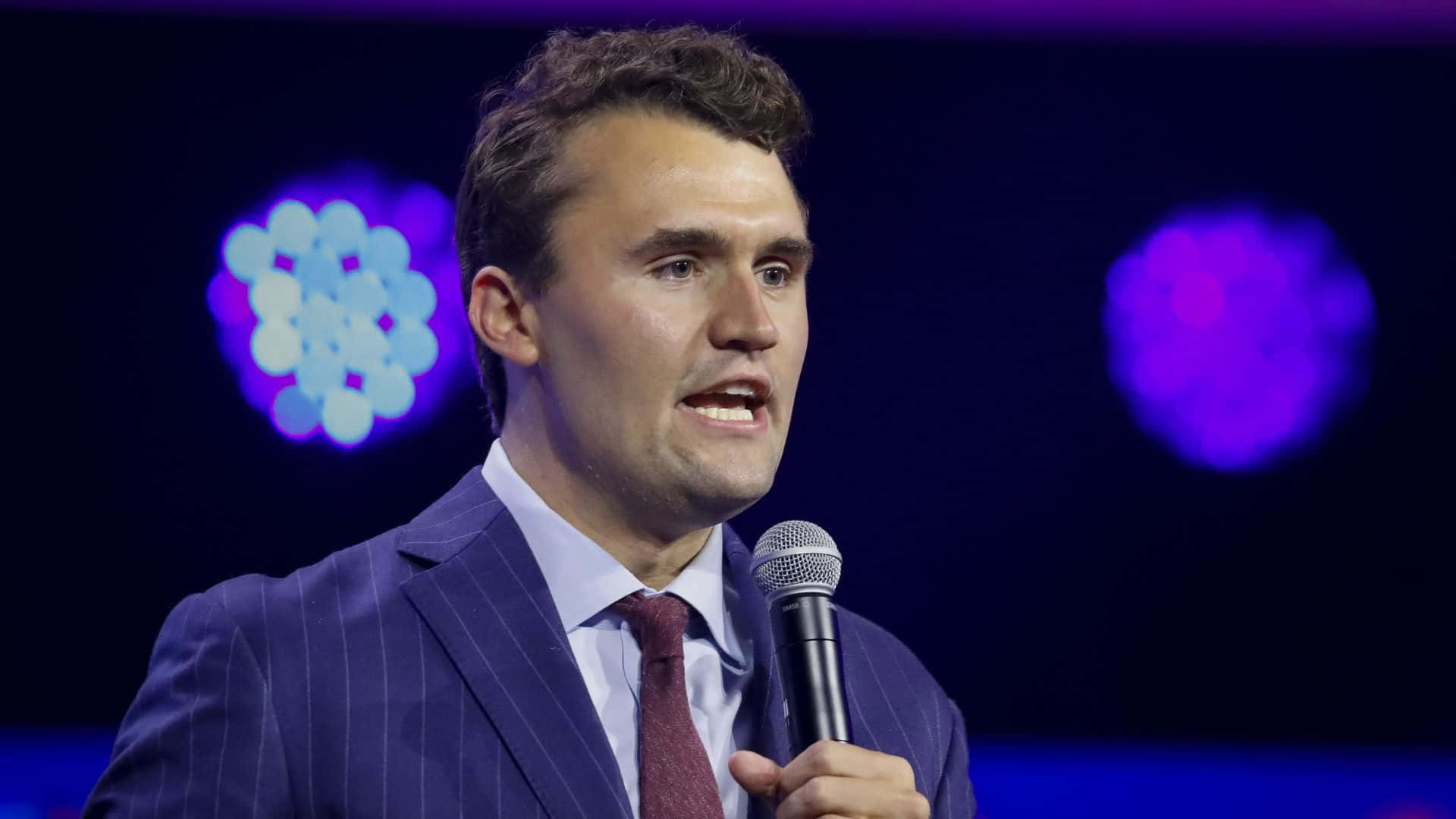 Charlie Kirk, blue pinstripe suit, microphone, Full HD Desktop Wallpaper