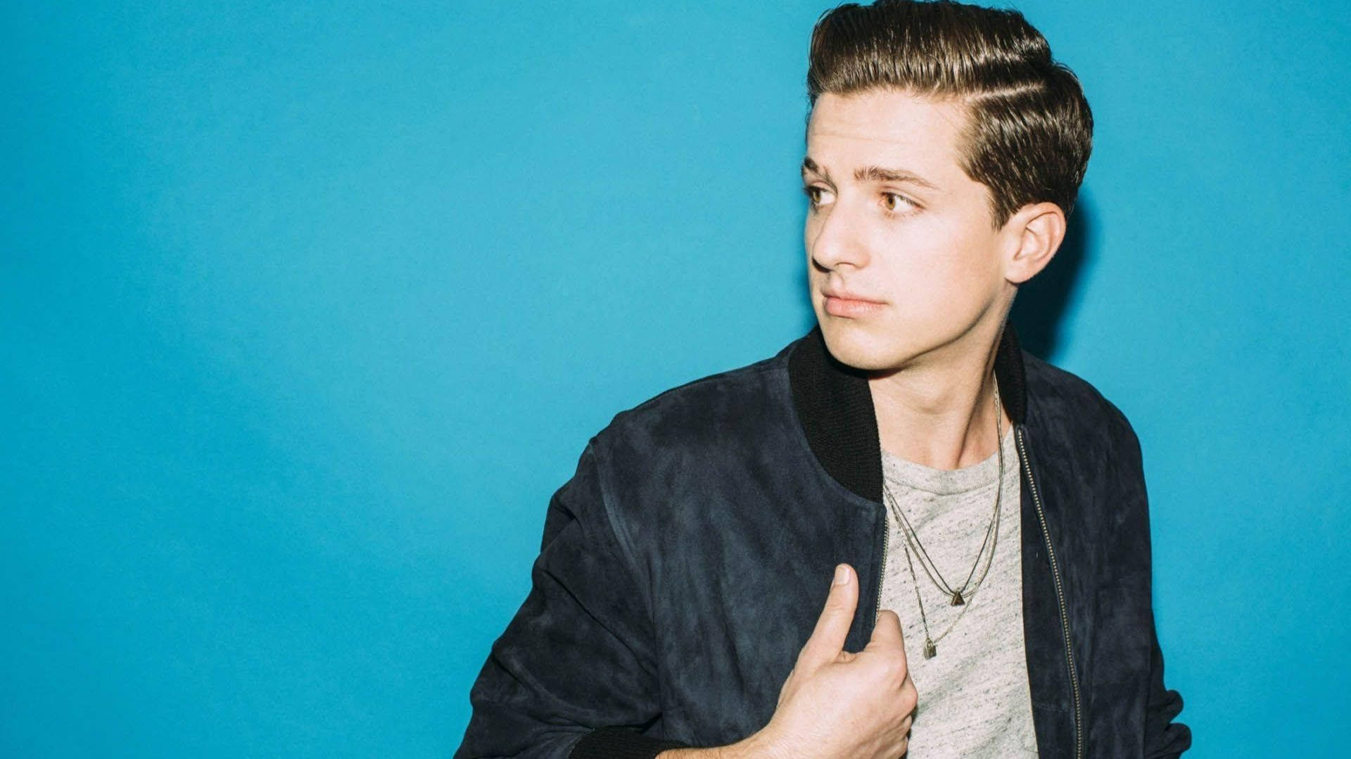 Charlie Puth, dark bomber jacket, solid blue studio background, Full HD Desktop Wallpaper