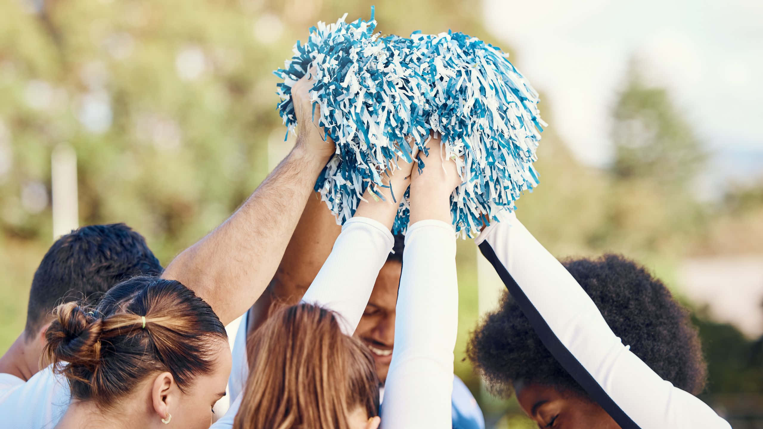 Team Cheer Huddlewith Pom Poms, blue and white pom-poms, diverse group of cheerleaders, 2K Desktop Wallpaper
