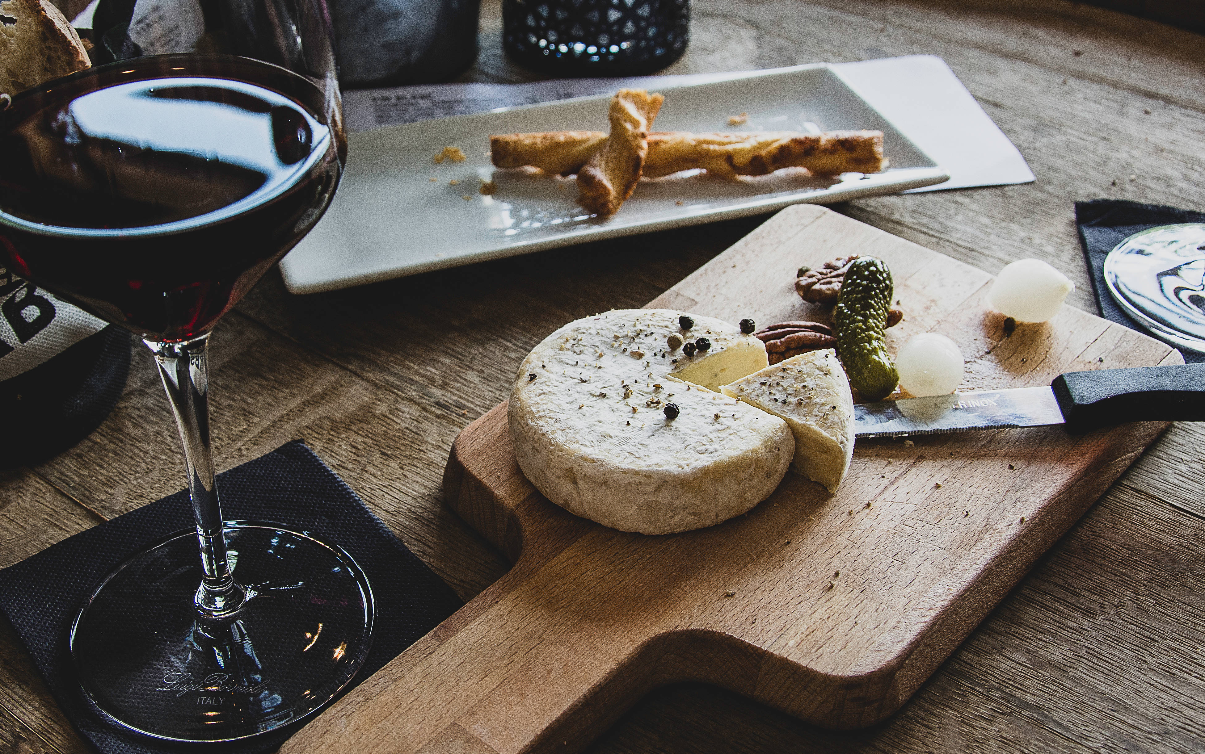 rustic wooden table, glass of red wine, cheese board, 4K Desktop Wallpaper