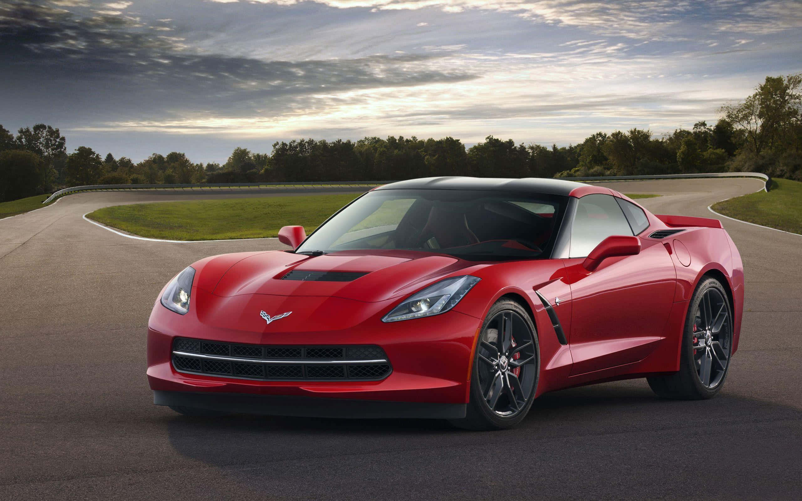 Chevrolet Corvette C7, vibrant red, winding asphalt track, 2K Desktop Wallpaper
