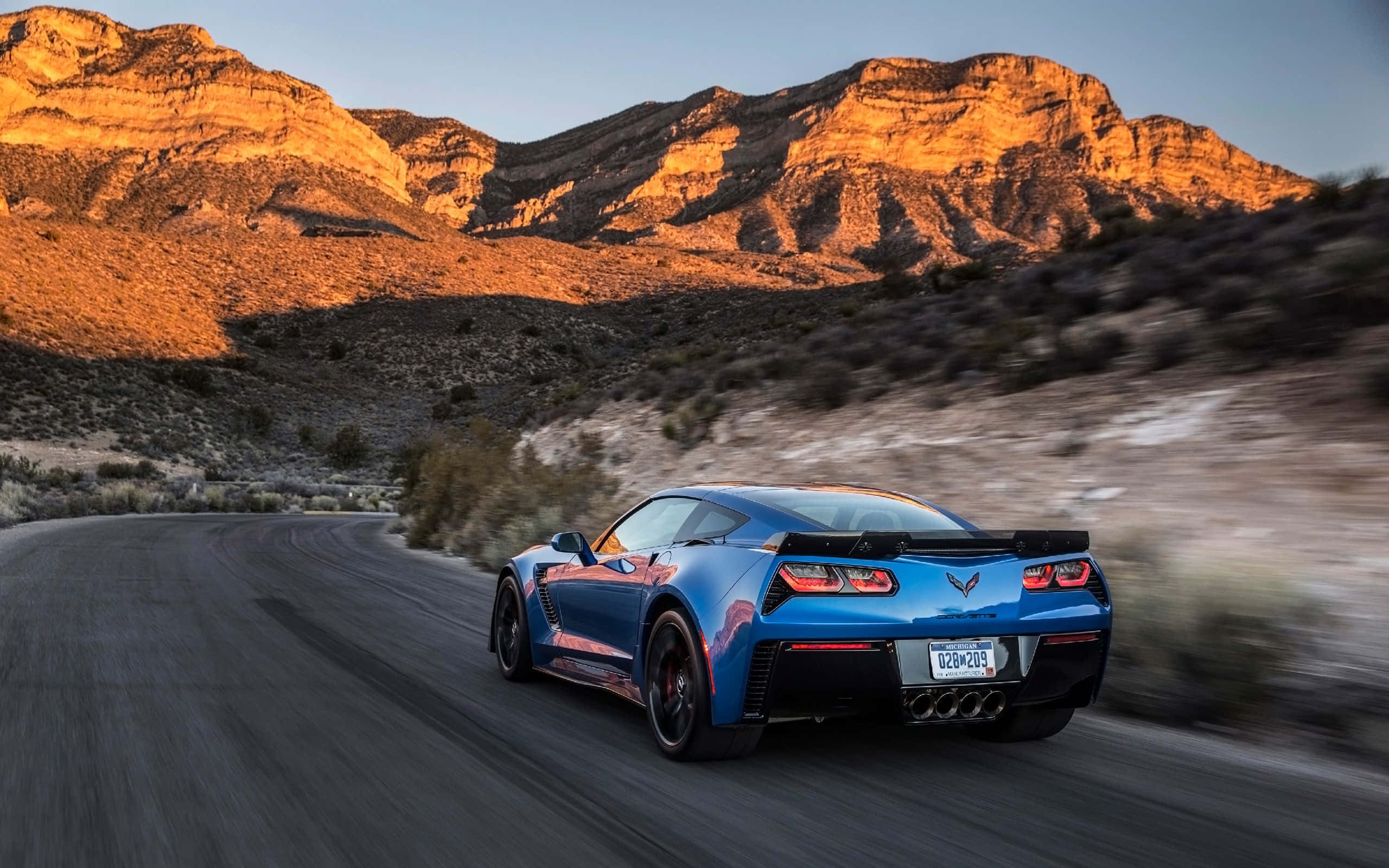 Chevrolet Corvette Z06, vibrant blue, winding desert road, 2K Desktop Wallpaper