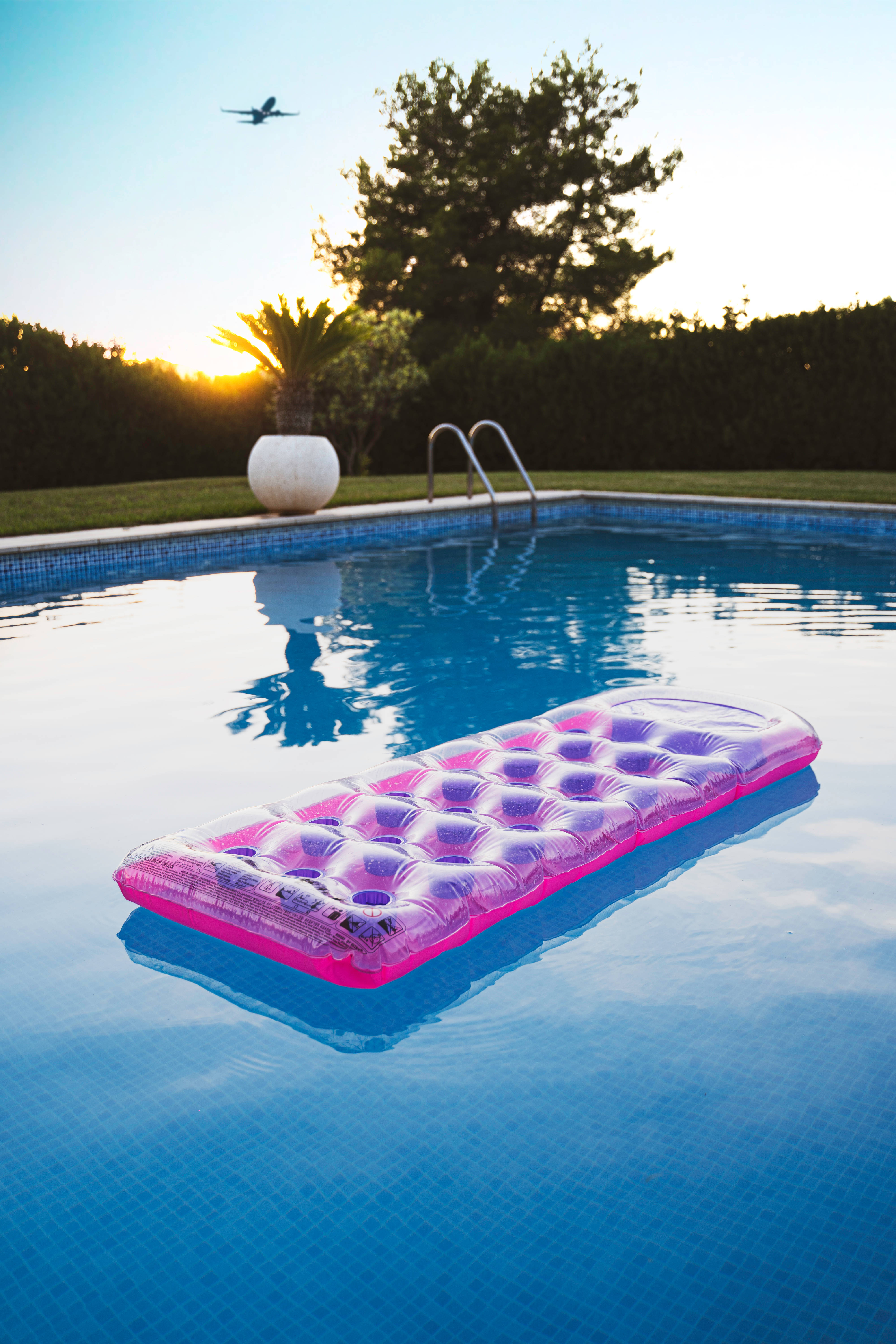 vibrant pink inflatable lounger, clear blue pool, sun sets, 5K Phone Wallpaper