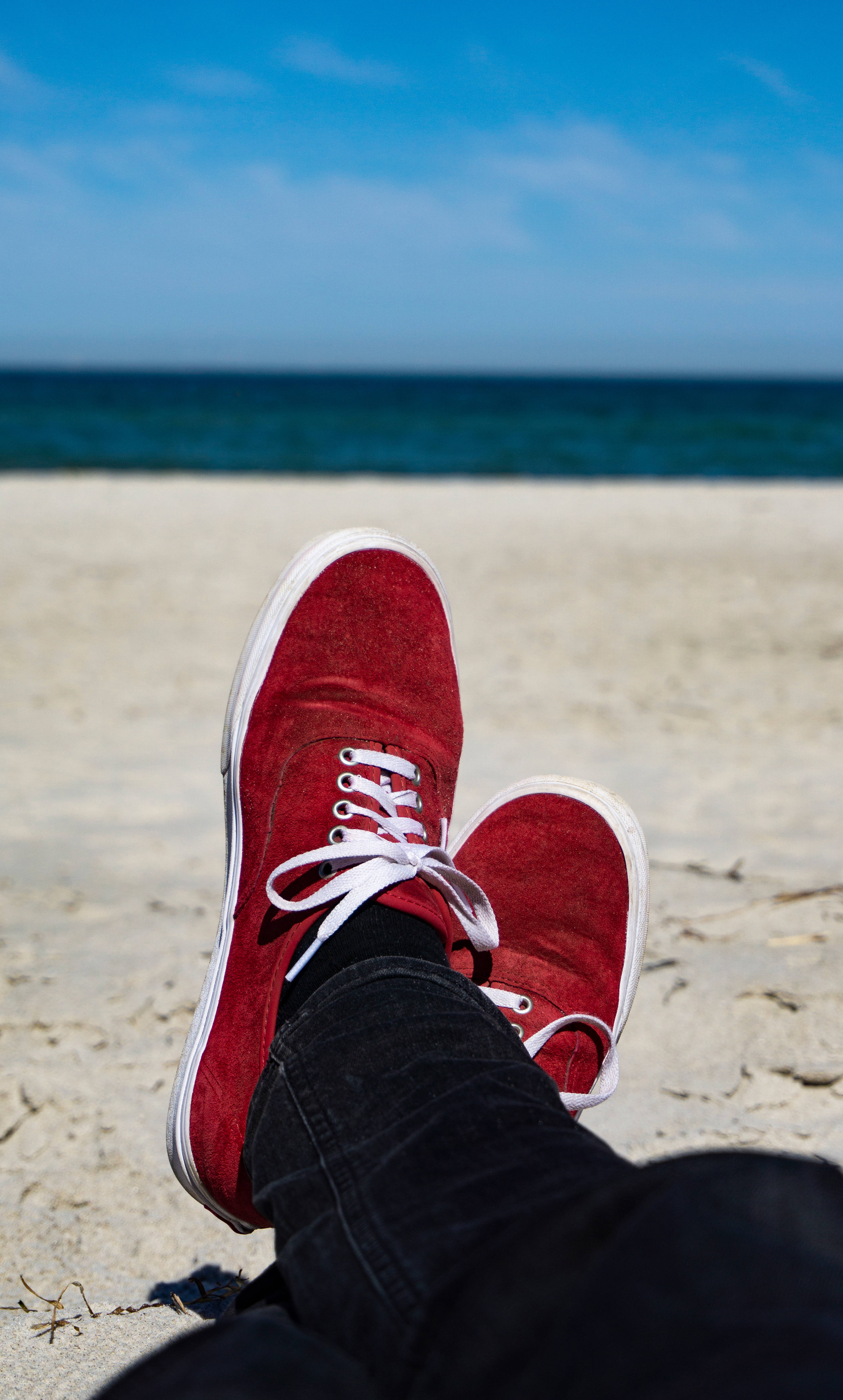 Red suede sneakers, sandy beach, turquoise ocean, 5K Phone Wallpaper
