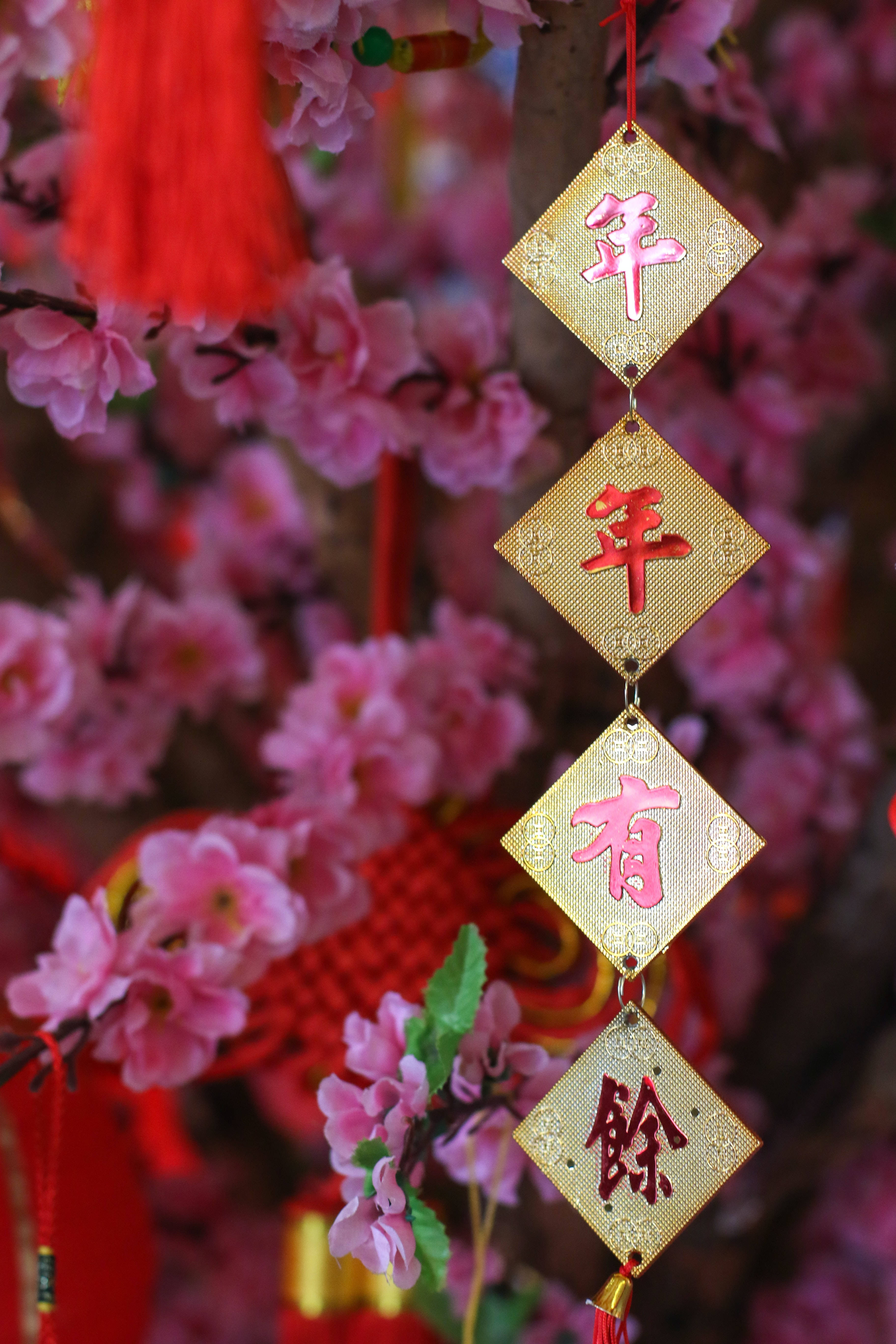 Chinese New Year, golden diamond-shaped charms, pink characters, 5K Phone Wallpaper