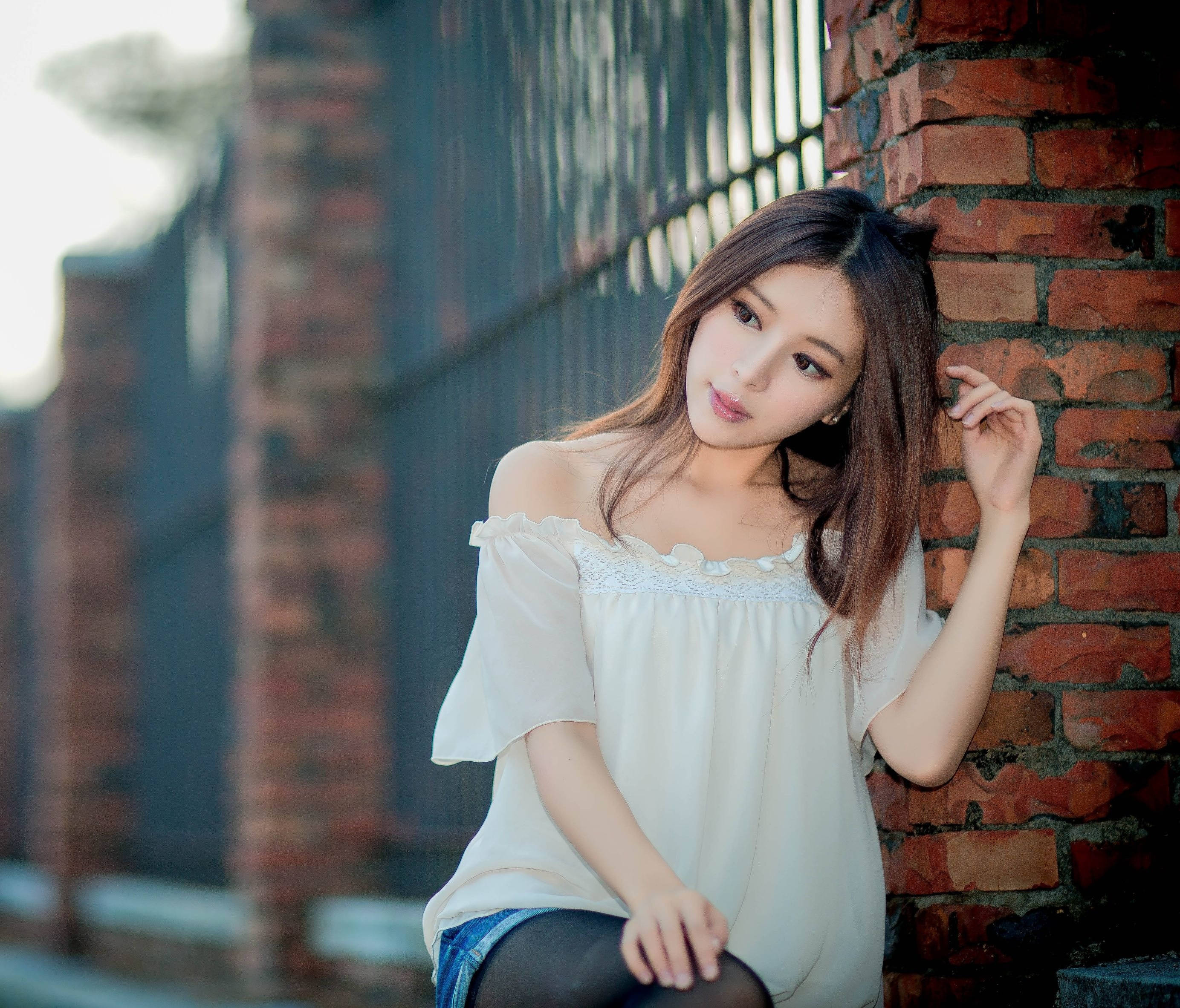 Chinese Girl, white off-shoulder top, weathered brick wall, 2K Desktop Wallpaper