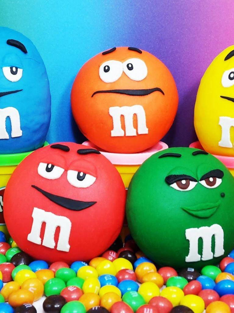 M&M's, colorful M&M's characters, bed of assorted candy, SD Phone Wallpaper