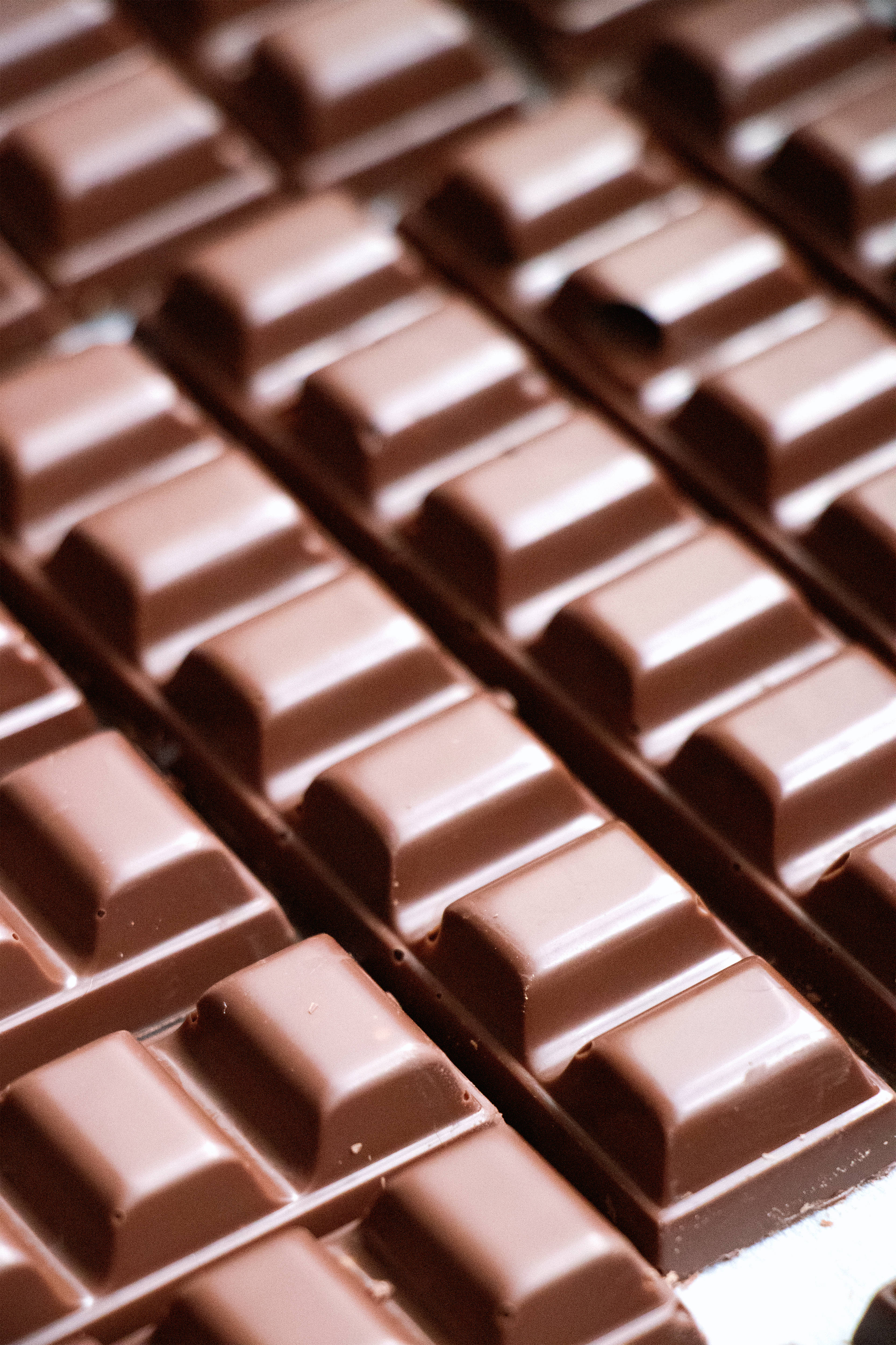 glossy milk chocolate bars, neat rows, soft shadows, 4K Phone Wallpaper